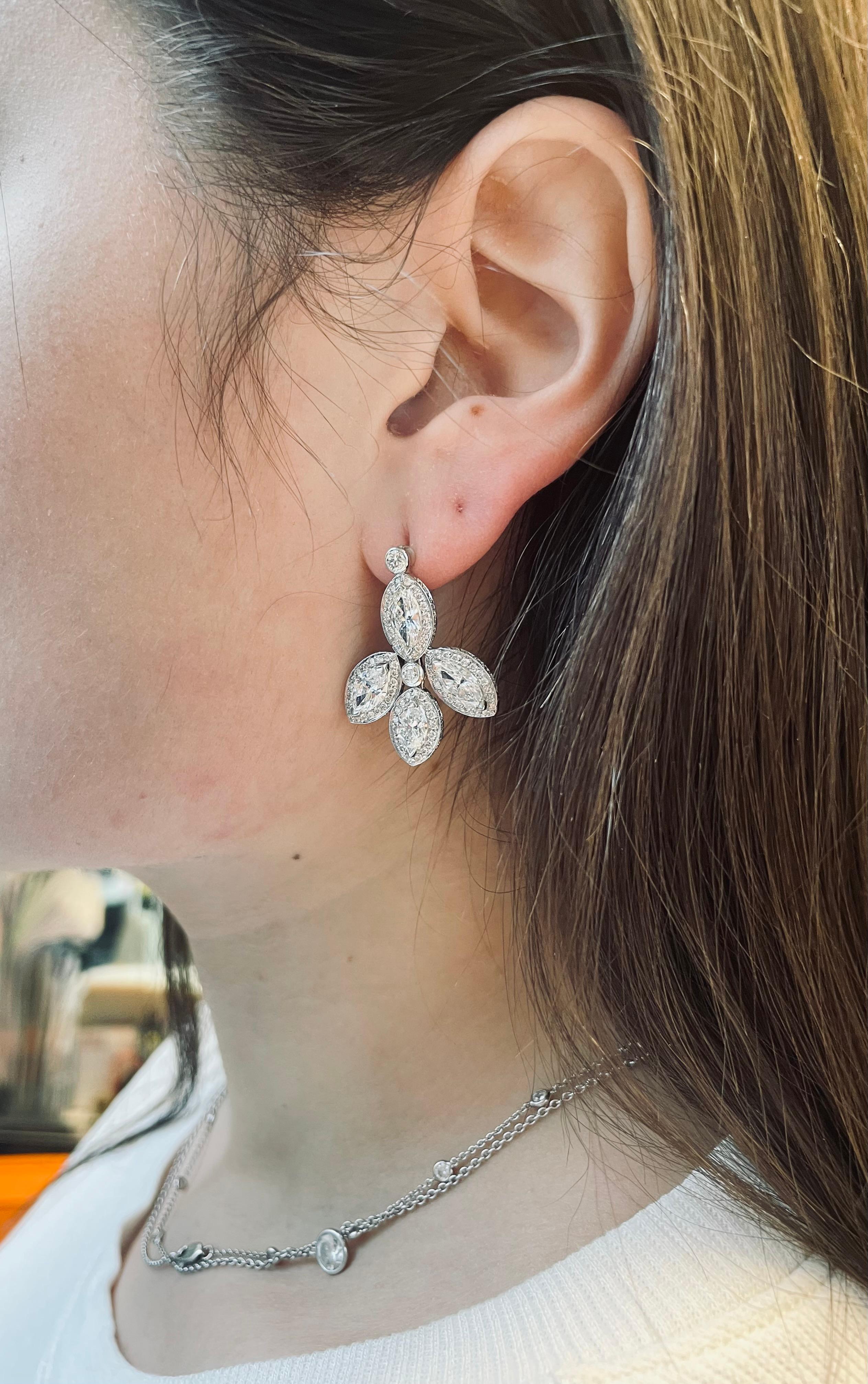 This beautiful set of leaf-themed diamond drop earrings features four marquise diamonds framed in micro-pave. The total weight of these earrings is approximately 7 carats. These flowery, dangling earrings are fun, but classic, and are made with