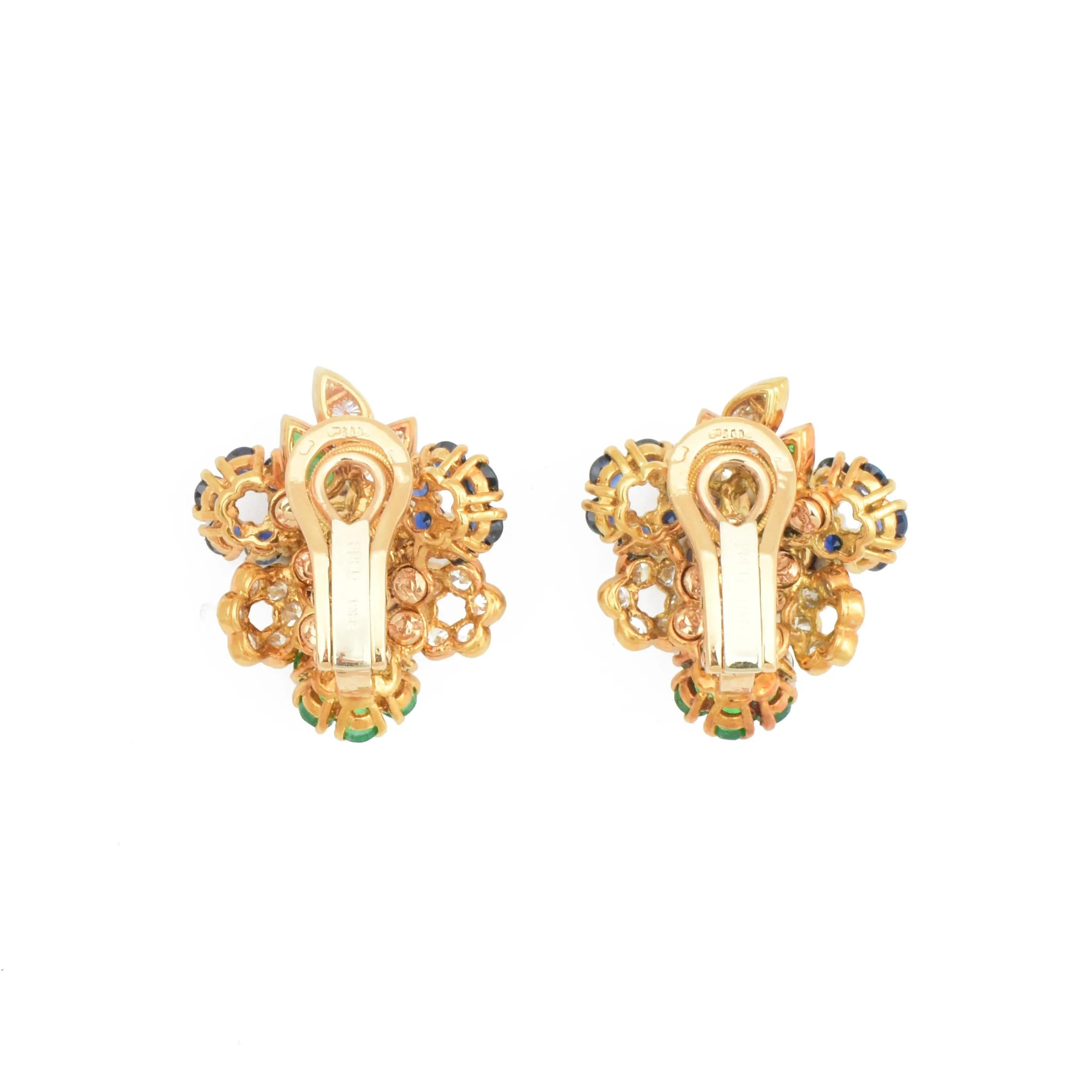 Ein atemberaubendes Paar bunte Clip-Ohrringe von Fred of Paris um 1970.

Die Modelle aus 18 Karat Gelbgold sind als stilisierte Blumensträuße gestaltet.

Besetzt mit feinen natürlichen Rubinen, Saphiren, Smaragden und Diamanten, komplett mit
