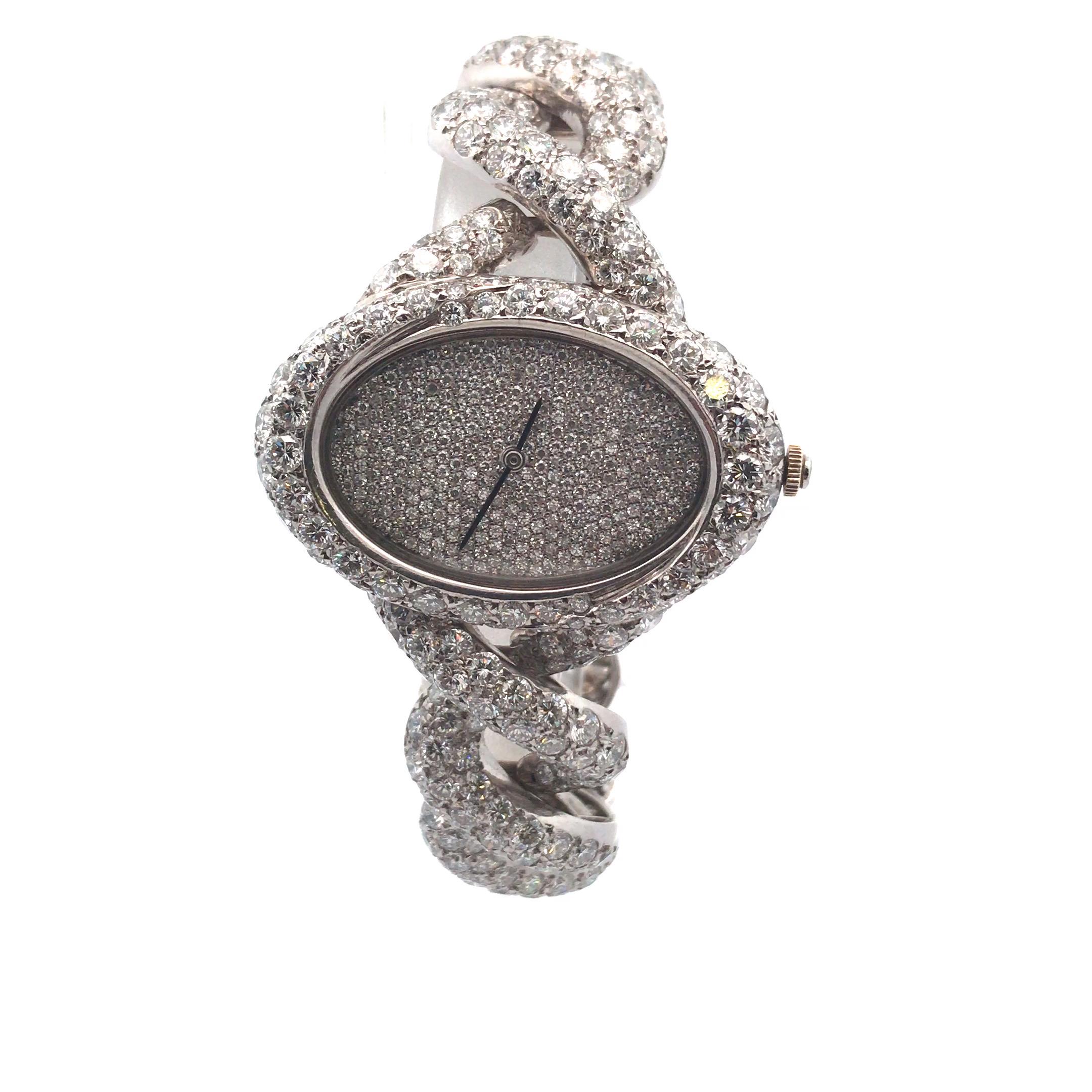 Une montre-bracelet pour dame en or blanc 18 carats, réalisée sur mesure par Fred, Paris. 
La montre présente un boîtier ovale mesurant environ 27 millimètres de diamètre, un cadran entièrement pavé de diamants et des aiguilles des heures et des