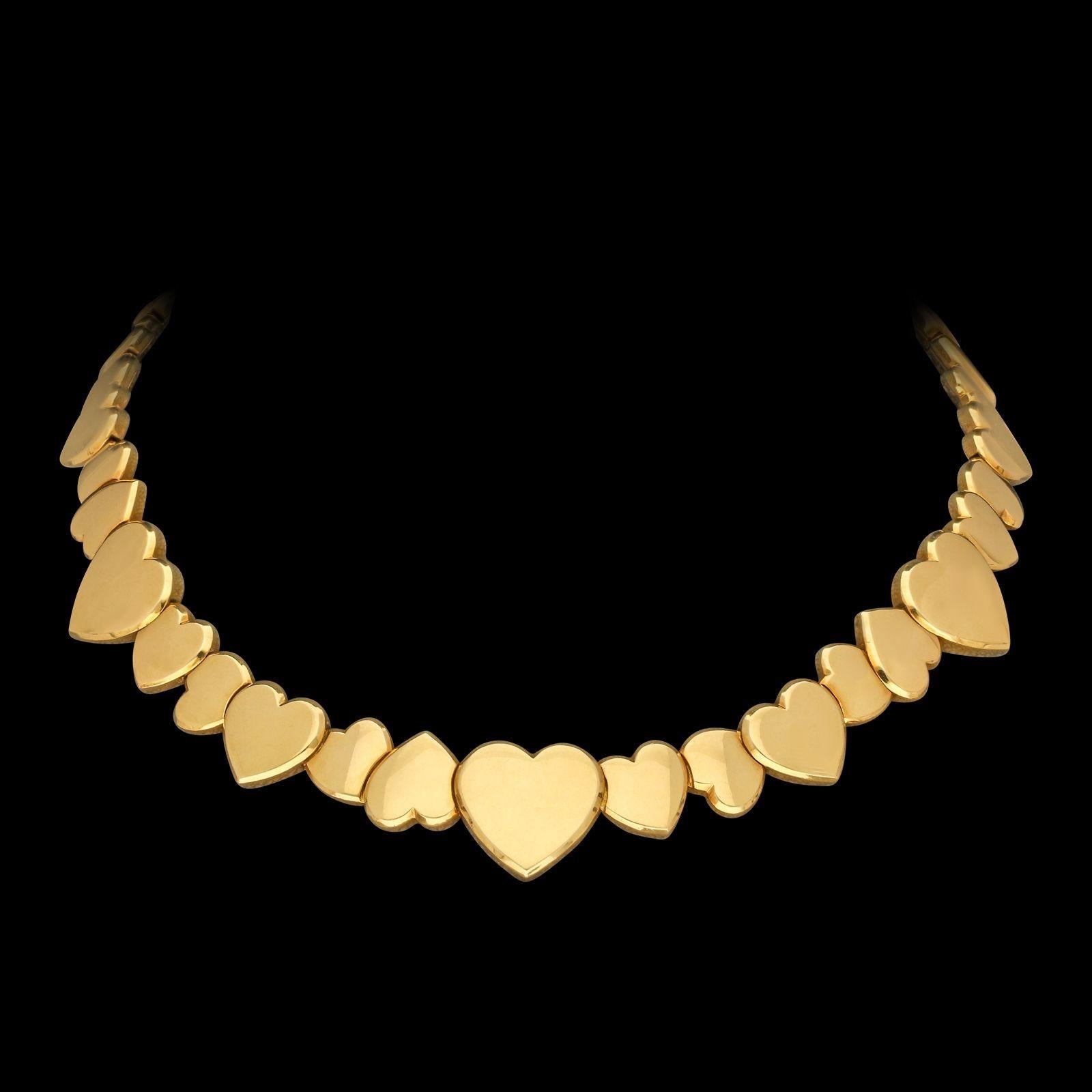 A stylish gold necklace by Fred Paris c.1980s, designed as a continuous row of overlapping chunky heart motifs of varying sizes, some pointing up and others down, the six largest hearts are symmetrical in shape and spaced evenly around the necklace