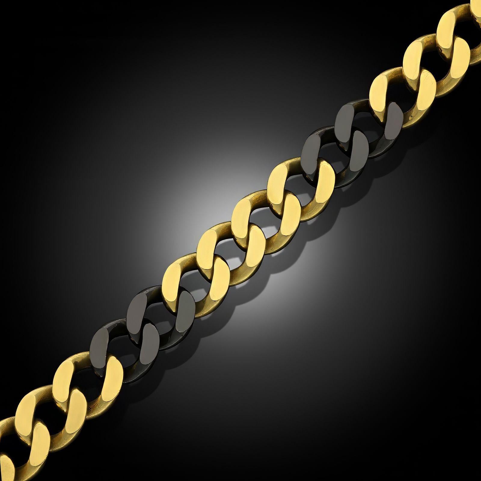 A vintage 18ct yellow gold bracelet by Fred Paris, circa 1980. The bracelet is a classic curb link, each of uniform size, all in 18ct yellow gold and interspersed with links with a black rhodium finish. Secured with a tongue and box