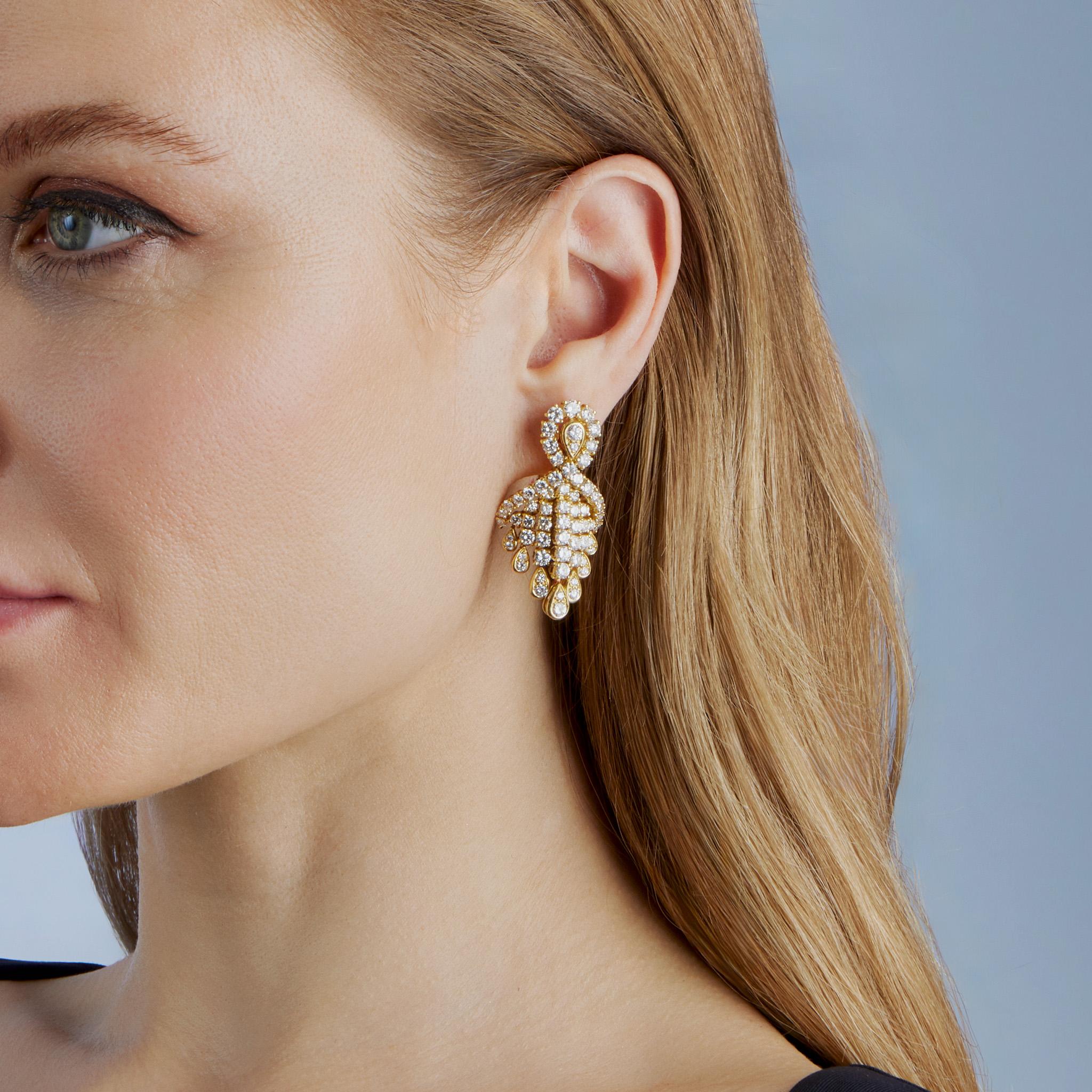 Created in the 1980s, these Fred pendant earrings are composed of 18K gold and diamonds. Each bombé-form earring is designed as pear-shaped top suspending lines of flexibly-set diamonds with pear-shaped fringe. Beautifully modeled and made to move