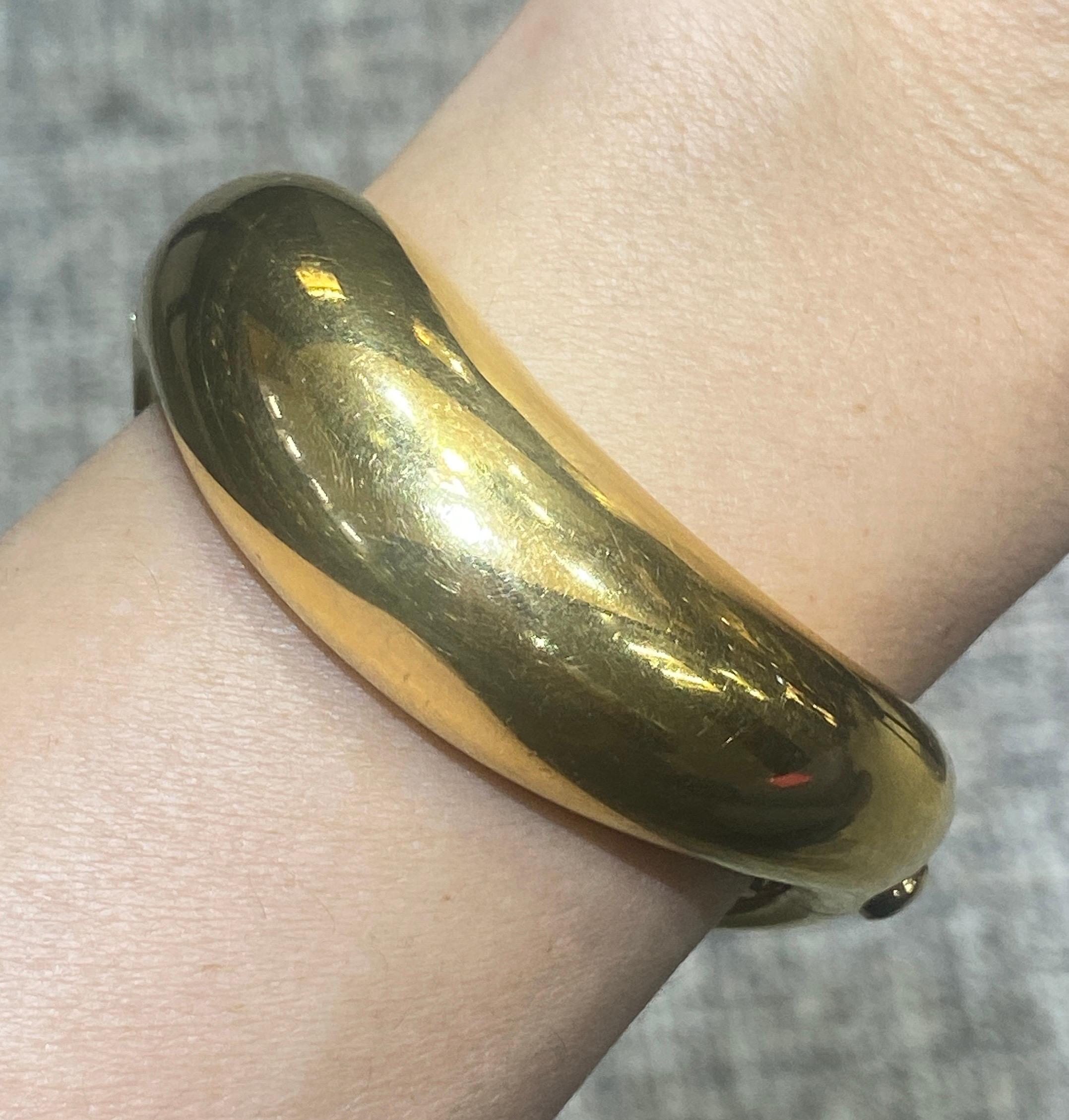 This 1980s Fred Paris bangle is made of polished 18k gold. The bangle is part of a set with a ring which is listed separately on 1stDibs.