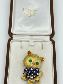 Fred Paris, broche chat en or jaune 18 carats, émail, corail et émeraude cabochon
