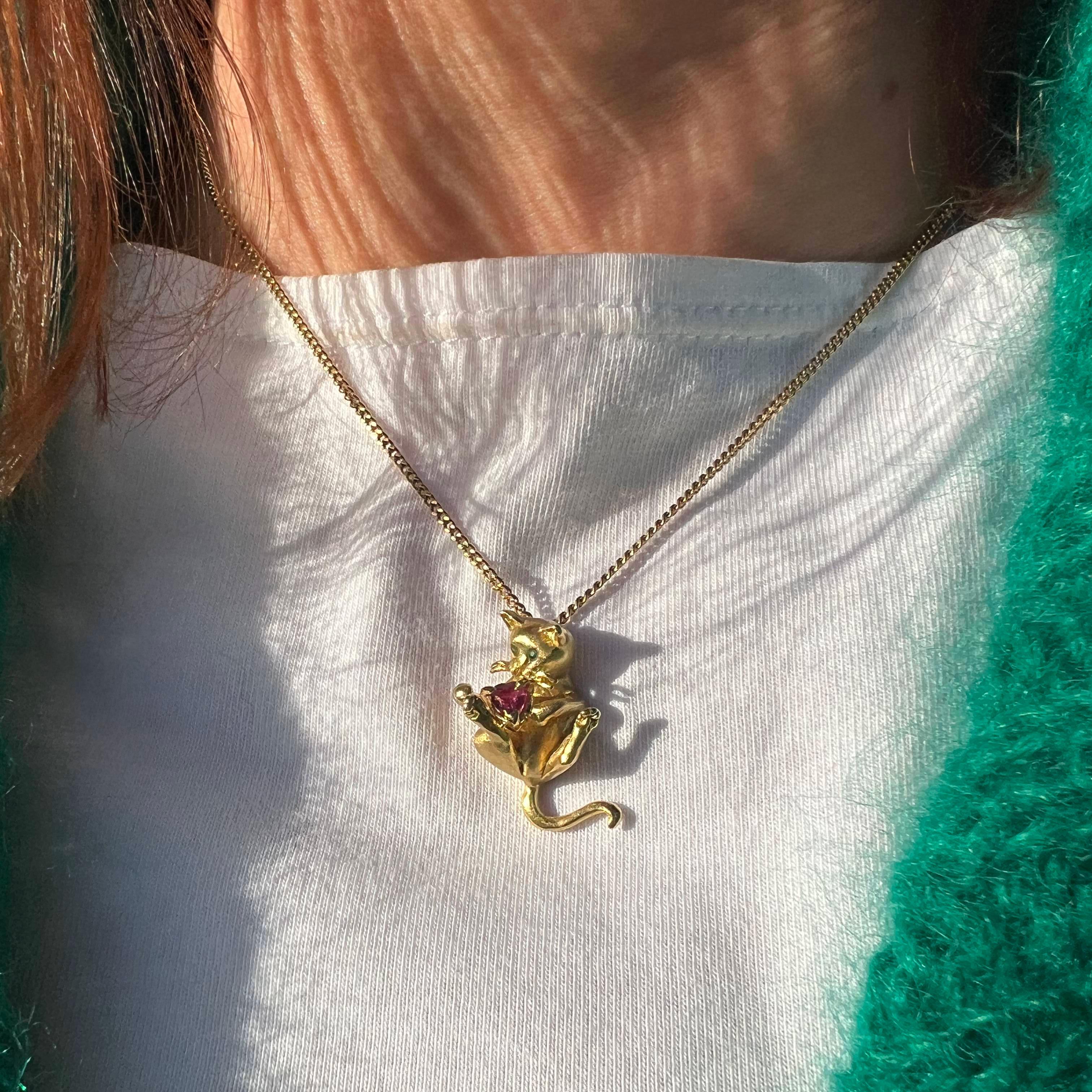 Fred Paris 18kt. yellow gold chain necklace with kitty holding ruby pendant. 

Introducing the exquisite Fred of Paris necklace, featuring a meticulously crafted kitty pendant. This stunning piece showcases remarkable attention to detail, capturing