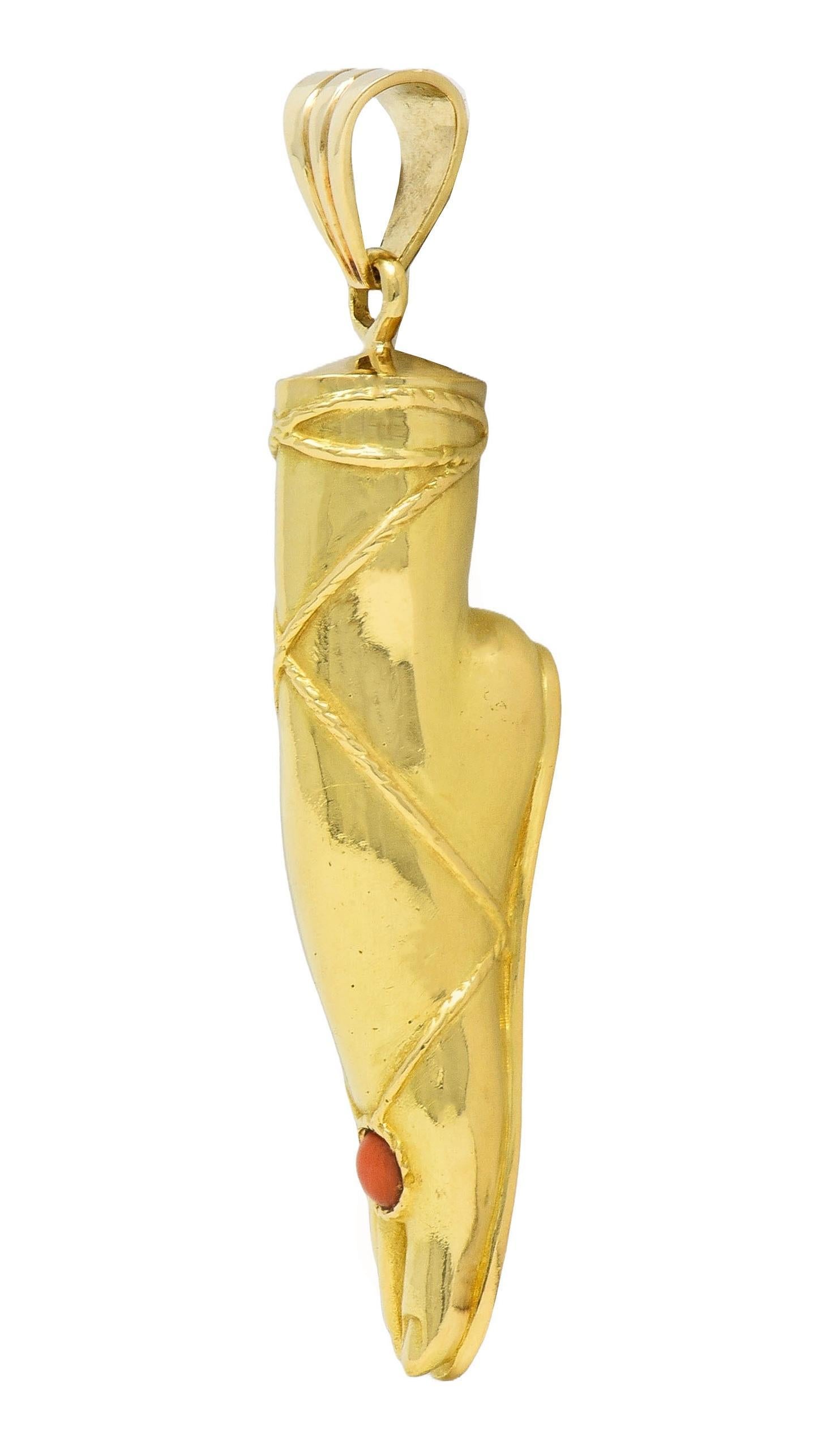 Designed as a dimensional foot laced into a Greek style sandal
Grooved and accented by a flush set coral cabochon on foot
Measuring 4.0 mm round - opaque orangey red in color
Suspended from tapered bale with fluted detail
Tested with partial French
