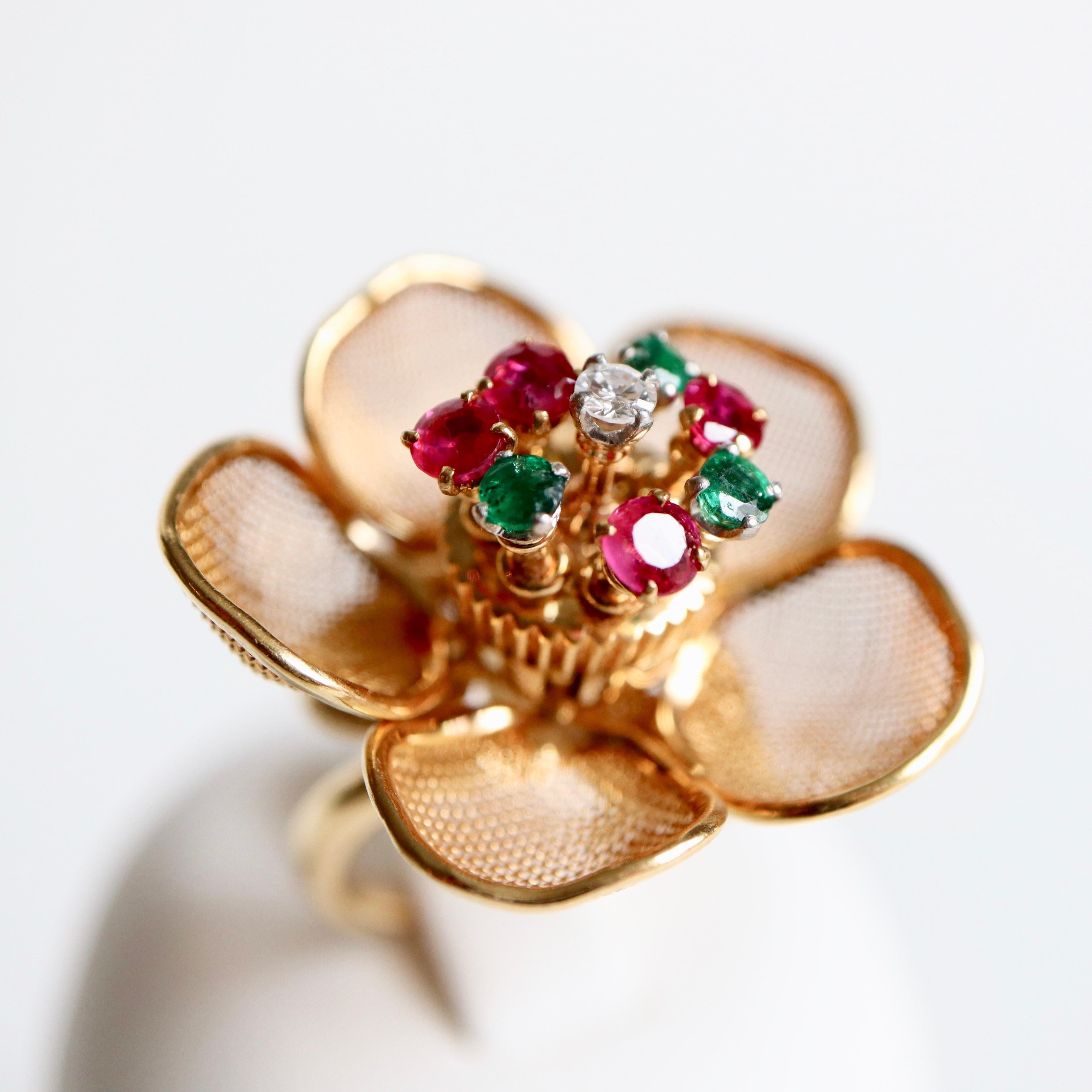 FRED PARIS Articulated Flower Ring retaining in its Center a Pistil composed of 4 Rubies, 3 Emeralds and a Diamond mounted on Articulated trembling Stems. The Petals in Gold Openwork are articulated and open and close according to the Will of the