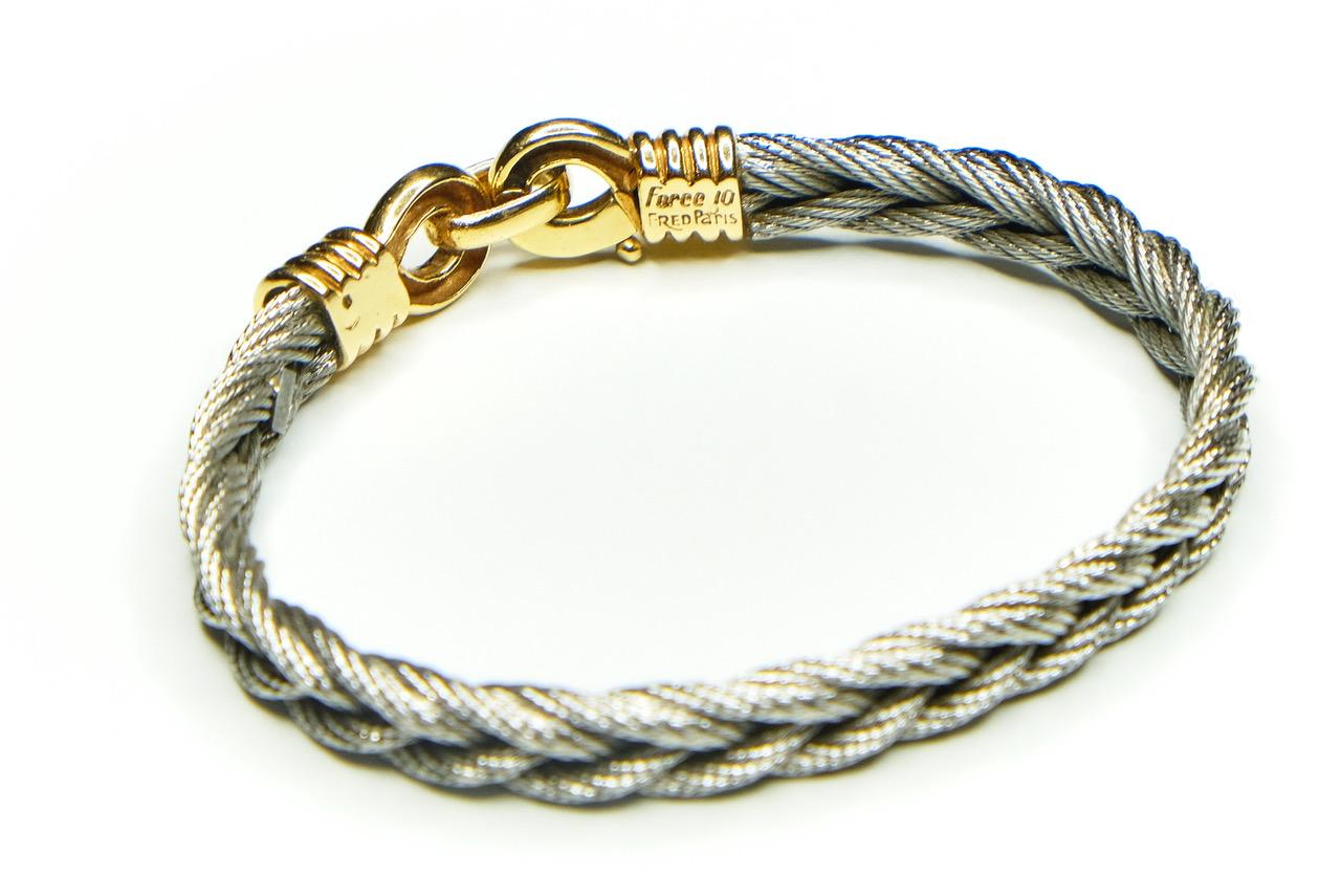 Fred Paris Force 10 sailing bracelet. Vintage stainless steel Cable and 18ct gold bracelet intended to be indestructible on the yachts of St Tropez. 

Width 6cms 