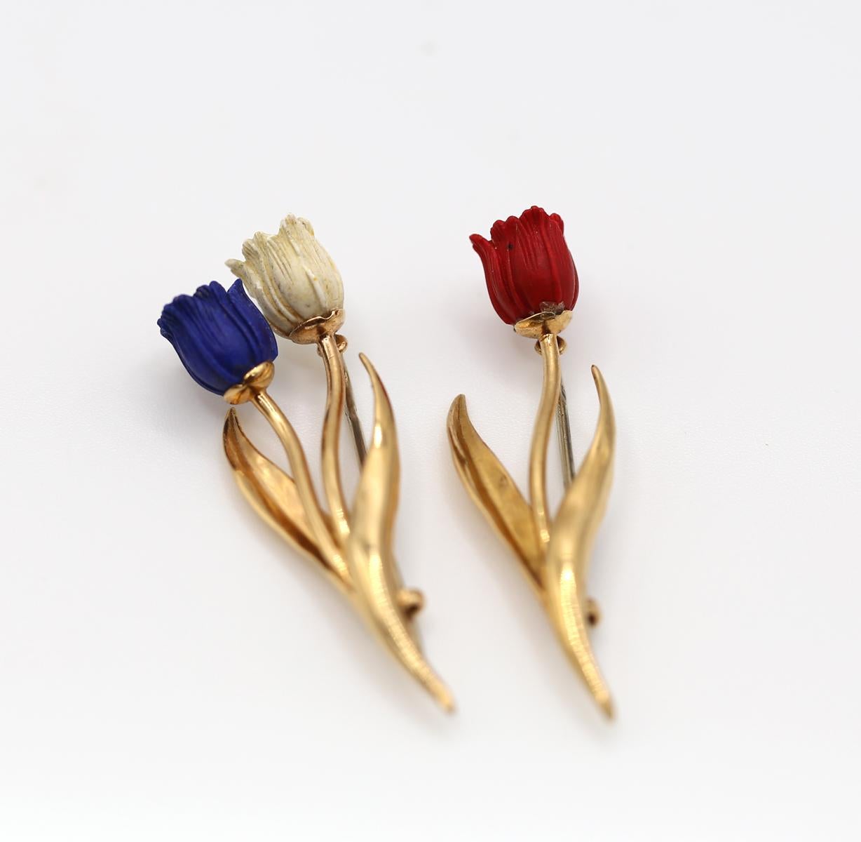 A Pair Of Blue Lapis White Red 18K Yellow Gold Tulip Brooches French Flag. Created by Fred Paris in France.

Consisting of two brooches designed as tulips with blue carved lapis lazuli, red and white hardstone petals atop yellow gold stems. Yellow