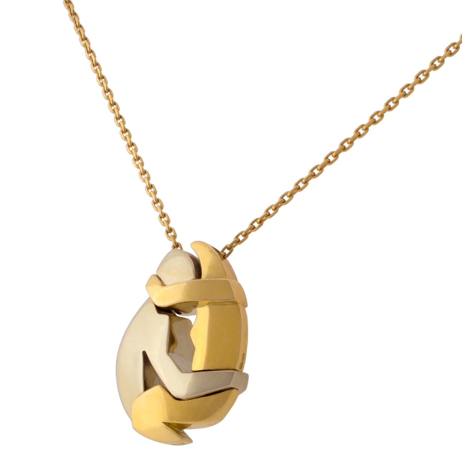 Pendant necklace by Fred, with a puzzle-like pendant formed of three separate pieces which fit together into the shape of two white and yellow 18K gold figures engaging in an embrace. Signed by Miroslav Brozek
Chain length: 36 cm (14.17 in)
Pendant