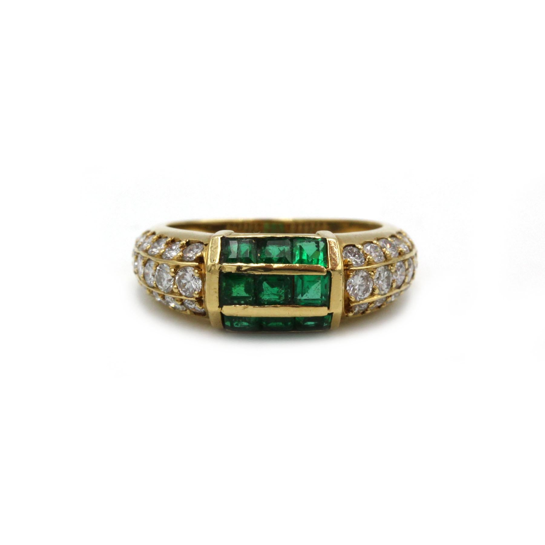 Bague sertie de pierres précieuses par Fred en or jaune 18 carats, présentant un bloc central d'émeraudes calibrées de taille carrée, flanqué de triples rangées de diamants brillants le long des épaules. La pièce affiche le caractère de la Maison
