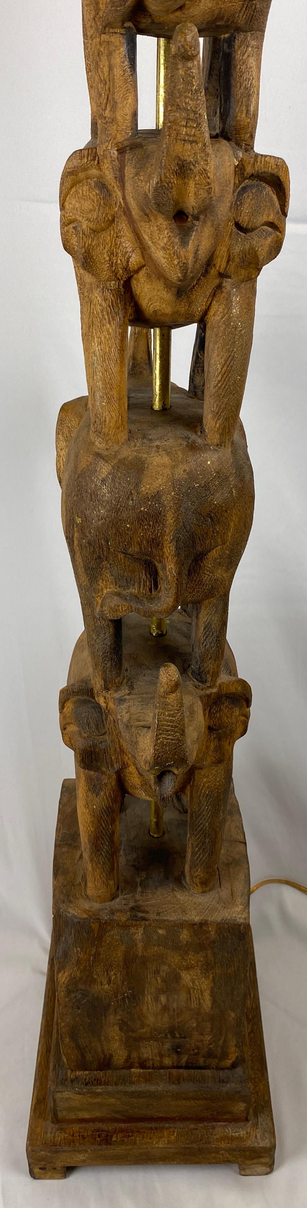Rare et unique, lampadaire organique moderne sculpté à la main avec de multiples éléphants, conçu par Frederic Cooper. Le tout en bois massif, rehaussé de petites traces de feuilles d'or. Le centre du laiton est recouvert de feuilles d'or et est en
