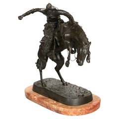 Sculpture en bronze "Bronco Buster" de Frederic Remington sur socle en marbre 20ème siècle