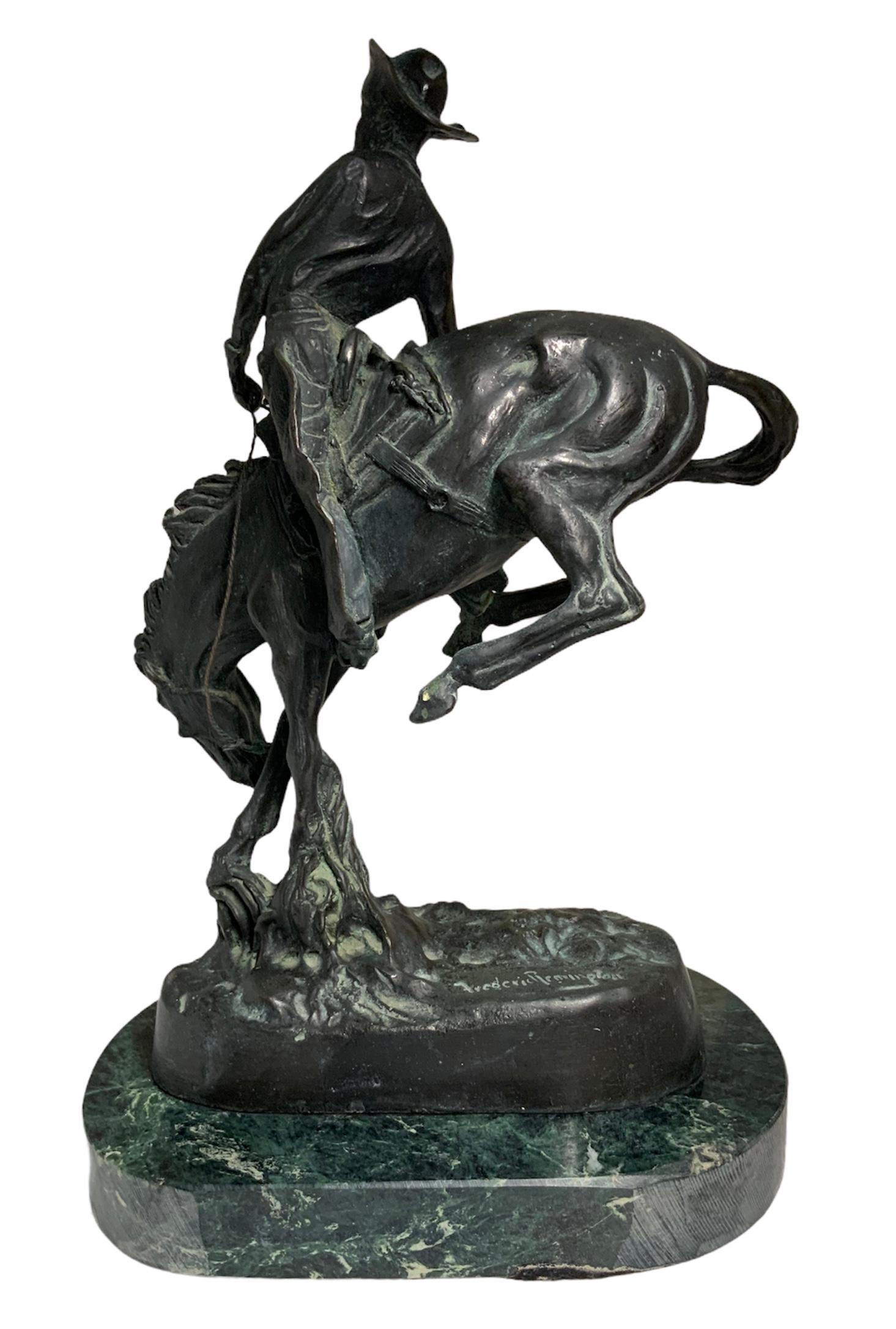 This is a Remington bronze sculpture depicting a cowboy riding a wild saddled horse. You can see the tension of the muscles of the horse and in the bent arc back of the cowboy. The back of the bronze base is signed Frederic Remington. The sculpture