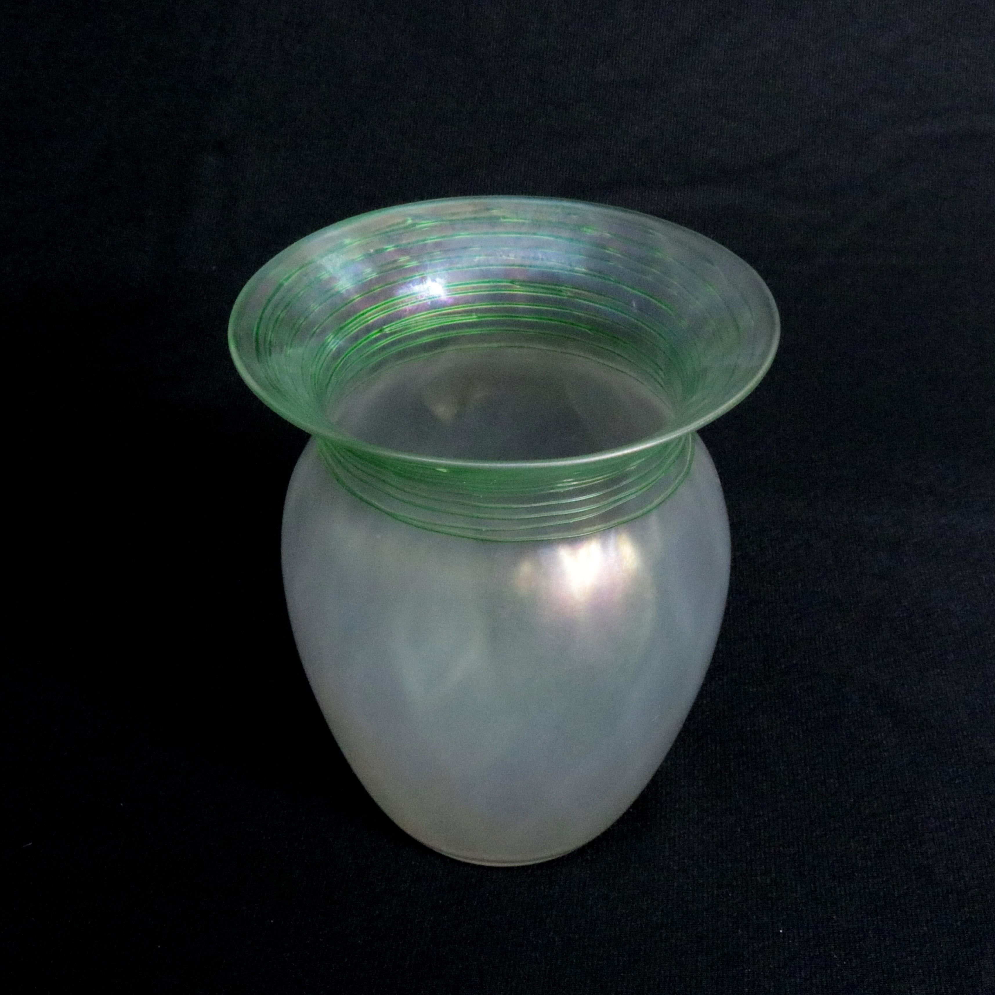 An antique vase by Steuben offers baluster shape in Verre de Soie art glass having optic applied green threading around flared neck with wide opening surmounting paneled vessel, polished pontil, signed with acid etched Steuben as photographed, early