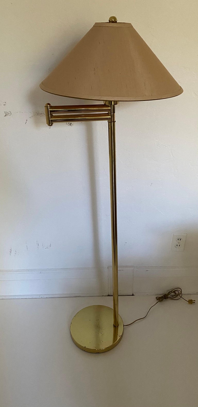 A vintage brass floor lamp with adjustable swing arm by Frederick Cooper.

Includes original beige silk shade and finial, also by Frederick Cooper.

Made in USA in the 1970s/1980s.

Signed on underside of base with stamped “FC6” mark; signed