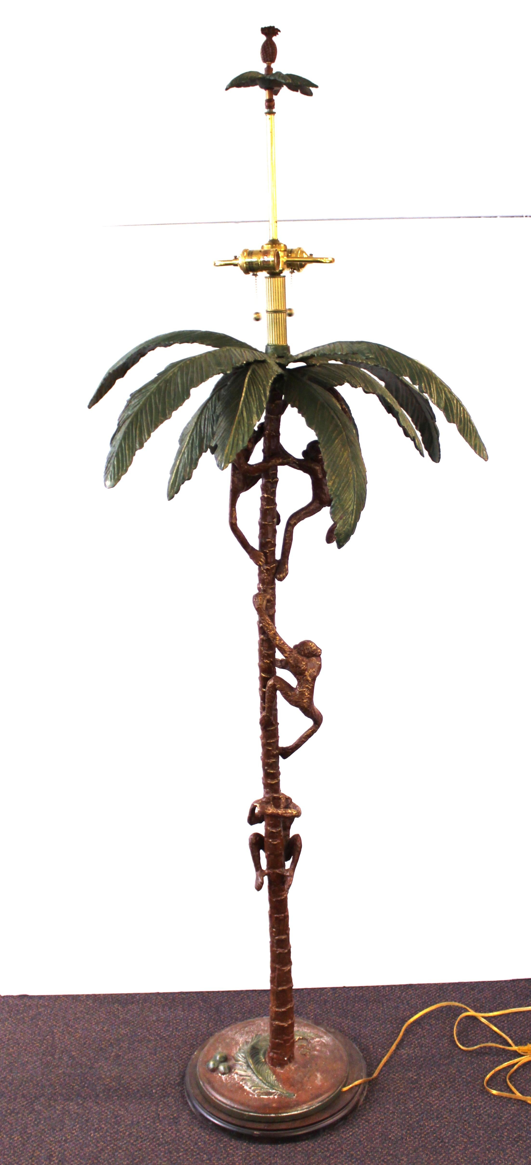 Hollywood Regency floor lamp in metal shaped like a palm tree with monkeys climbing up to grab coconuts. The piece was designed by Frederick Cooper and has a label on the light sockets. A pineapple finial tops of the lamp. In great vintage condition.