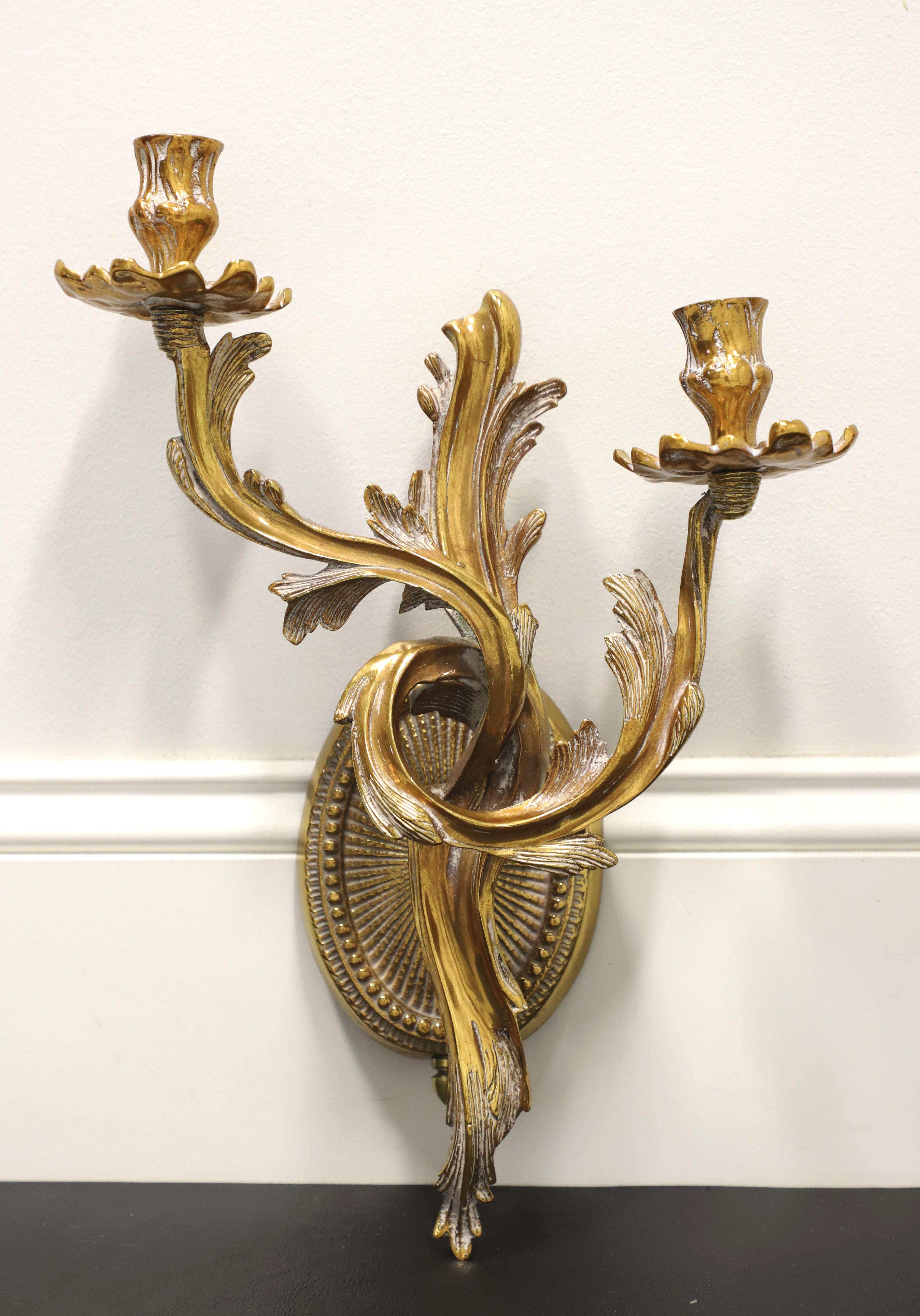 A pair of Rococo style candle wall sconces by Frederick Cooper. Solid brass decoratively sculpted in a swirl & acanthus leaves form, with two arms, two candleholders, and a decorative oval wall plate. Wall mounting accessories are included. Made in