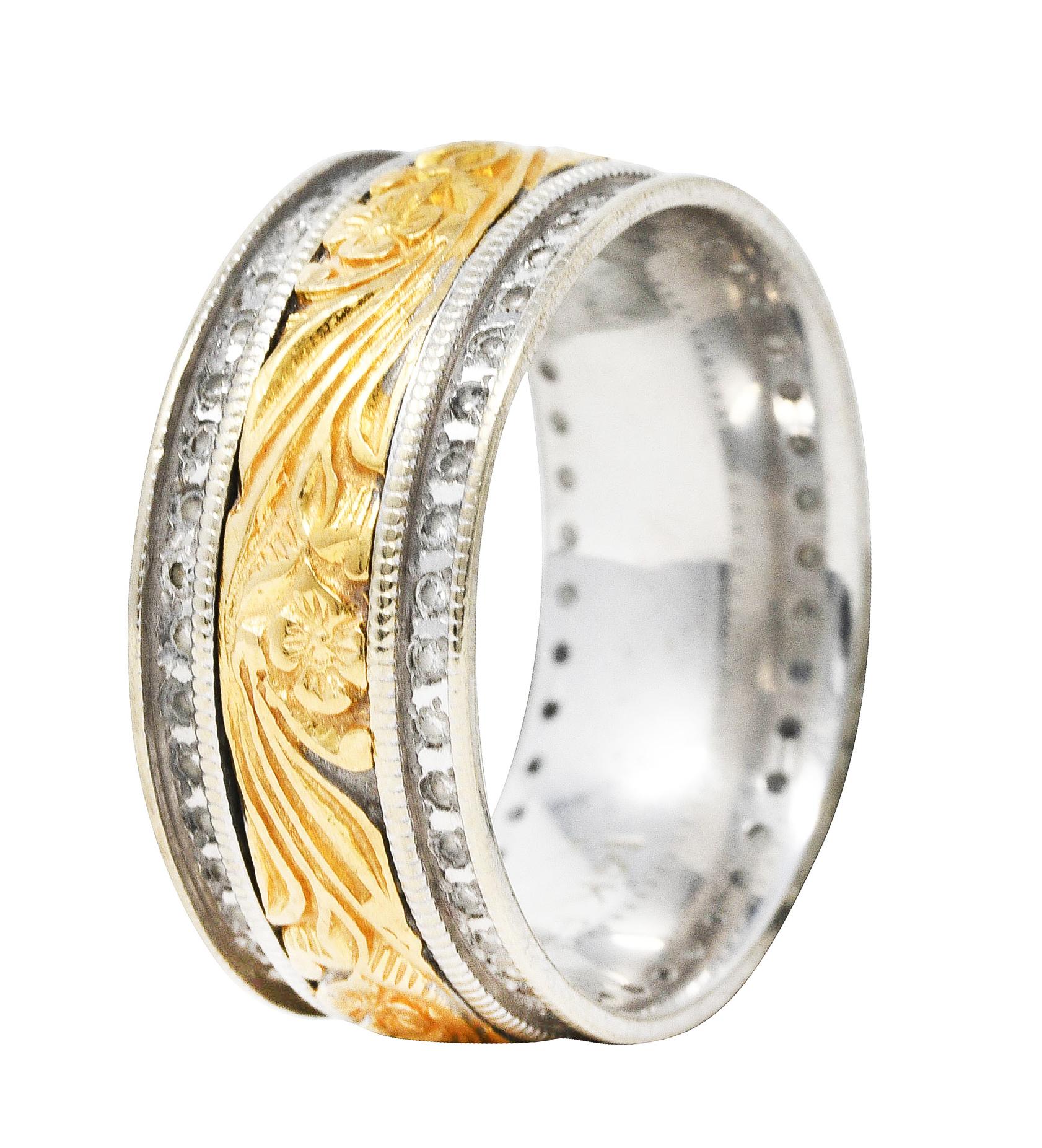 Wide band ring centers repoussè gold depicting highly rendered scrolling florals

Flanked by white gold with a recessed groove accented by round brilliant cut diamonds

Weighing in total approximately 1.00 carat with G/H color and SI