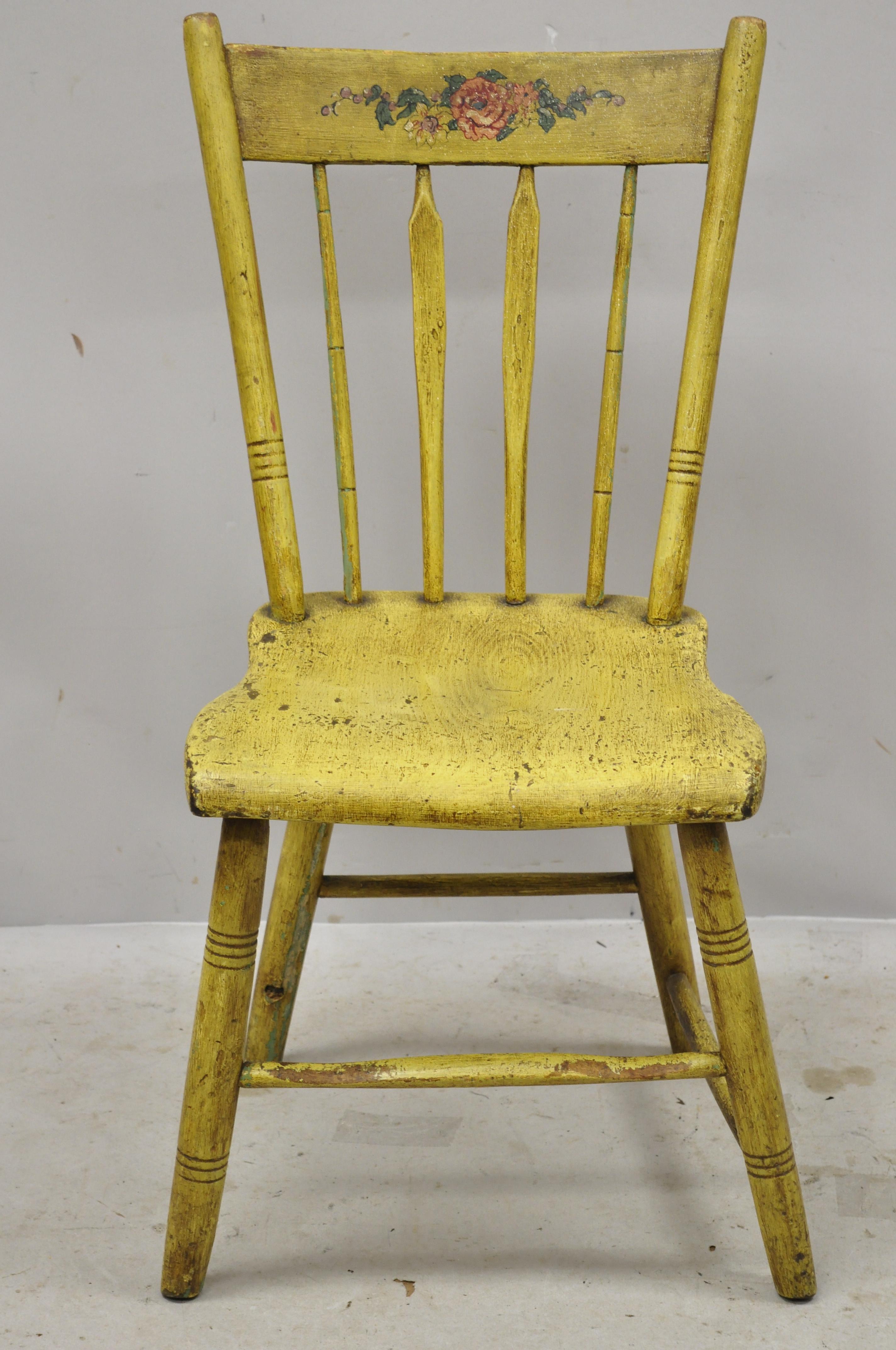Frederick Loeser & Co yellow American Primitive Hitchcock style painted side chair (B). Item features floral painted backrest, spindle back, carved stretcher base, remarkable patina, solid wood frames, yellow distressed finish, very nice antique