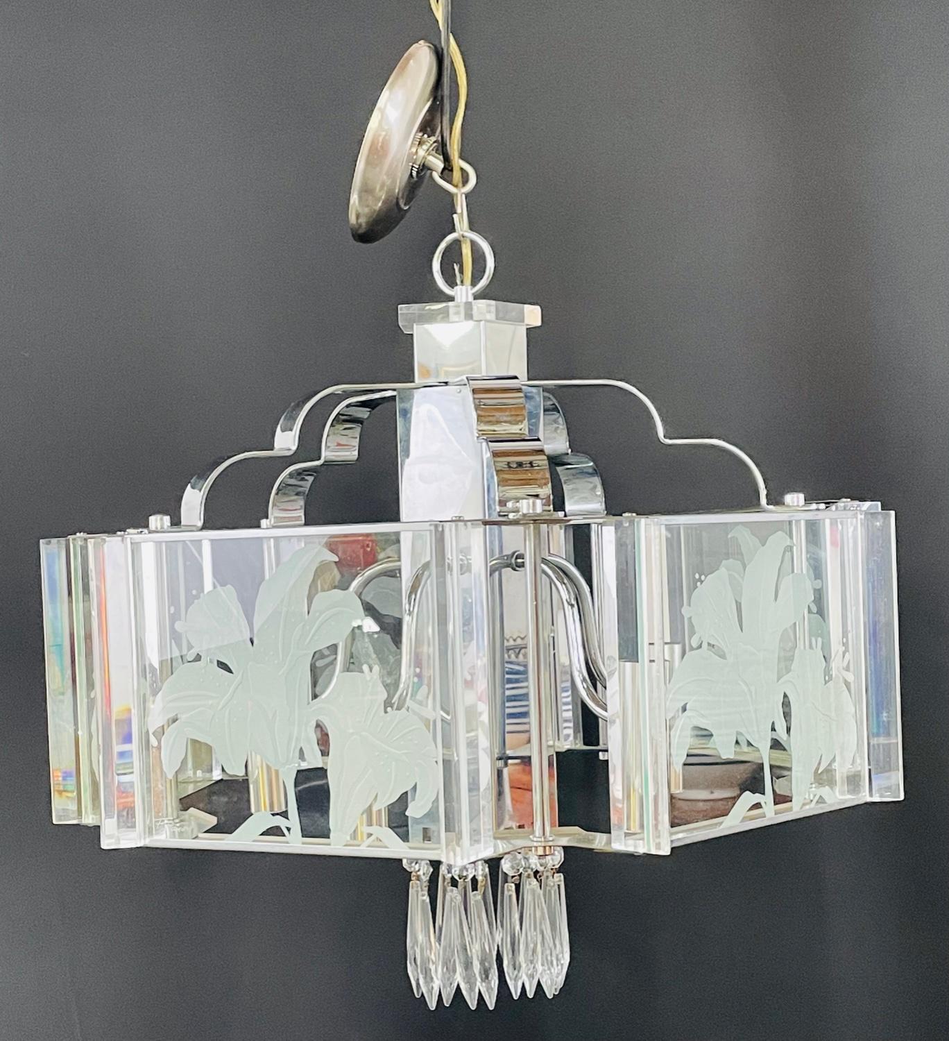 An exquisite Frederick Ramond Art Deco style hexagonal chandelier or pendant featuring 5 glass panes with a beautiful flower etching design framed in lucite and attached around a chrome column ending with crystals in the bottom. The chandelier has 5