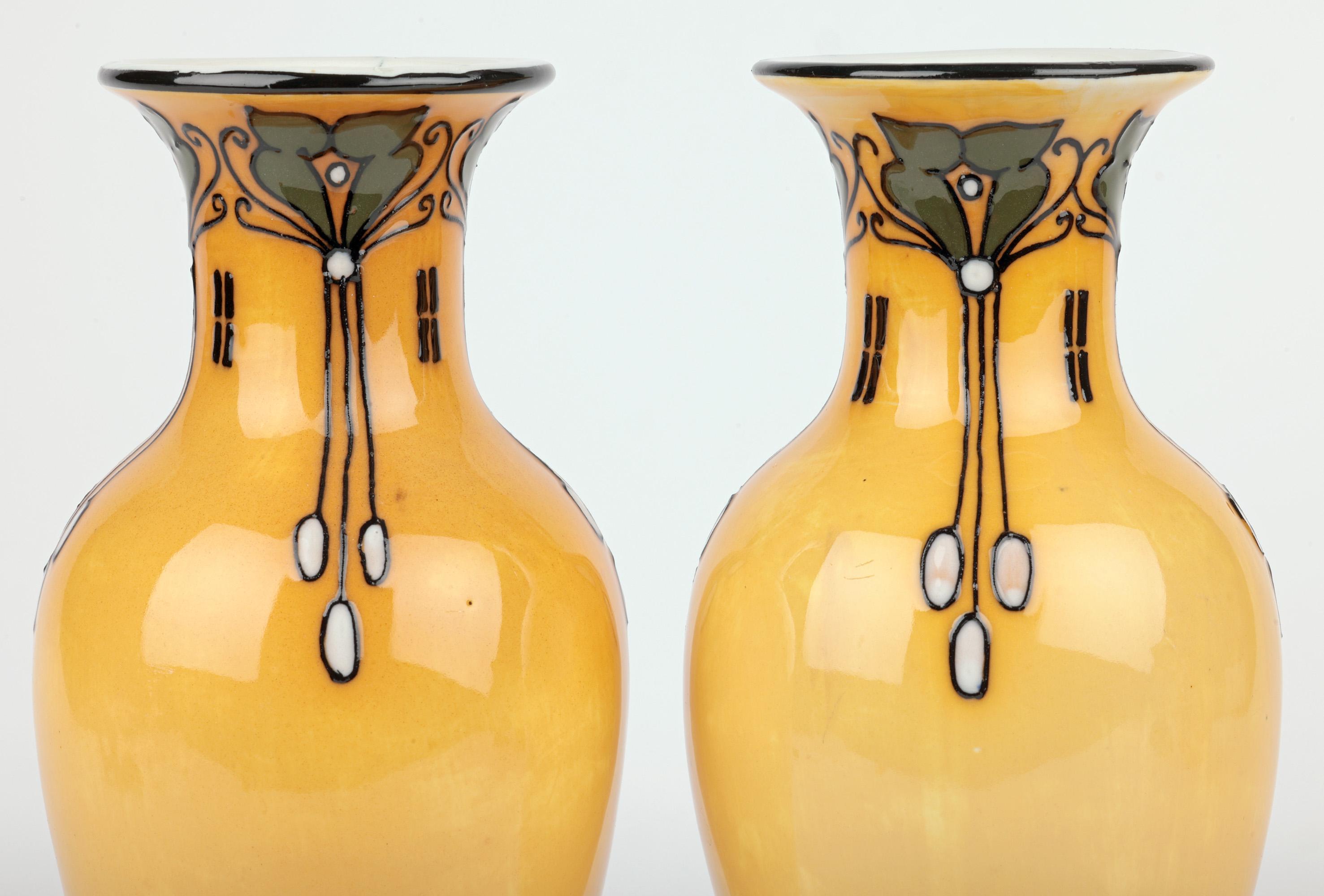 Una splendida coppia di vasi tubolari Wood & Son Elers Ware in stile Art Nouveau, disegnati da Frederick Rhead e risalenti al 1915 circa. Questa elegante coppia di vasi in porcellana è di forma alta e bulbosa e poggia su un bordo non smaltato con