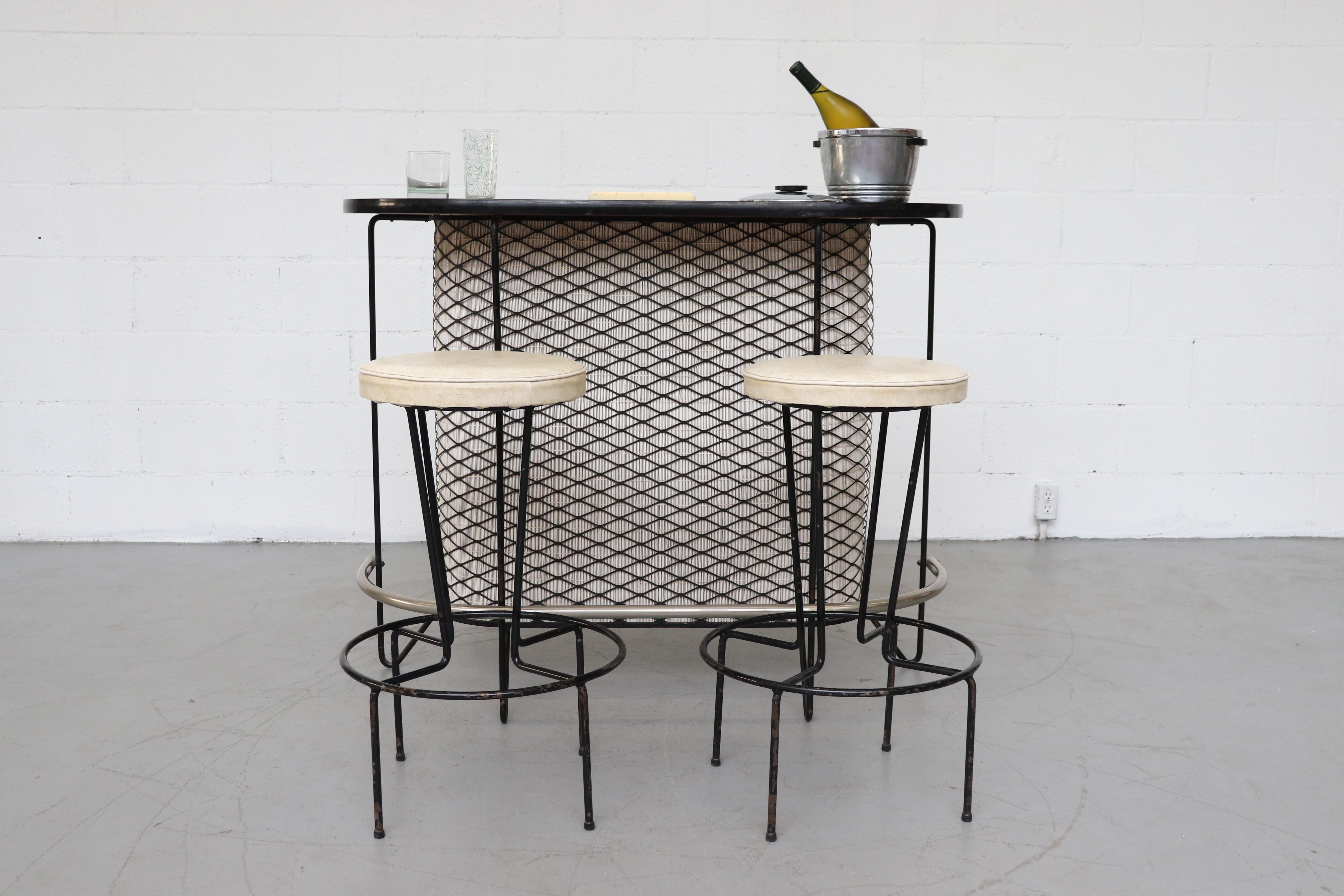 Frederick Weinberg bar midcentury bar and stool set. Bar features cream bamboo panel behind black metal screen. Stools measure: 18.5 x 14 x 28.5 with cream upholstered seats and black enameled metal legs. Very original condition with visual wear and