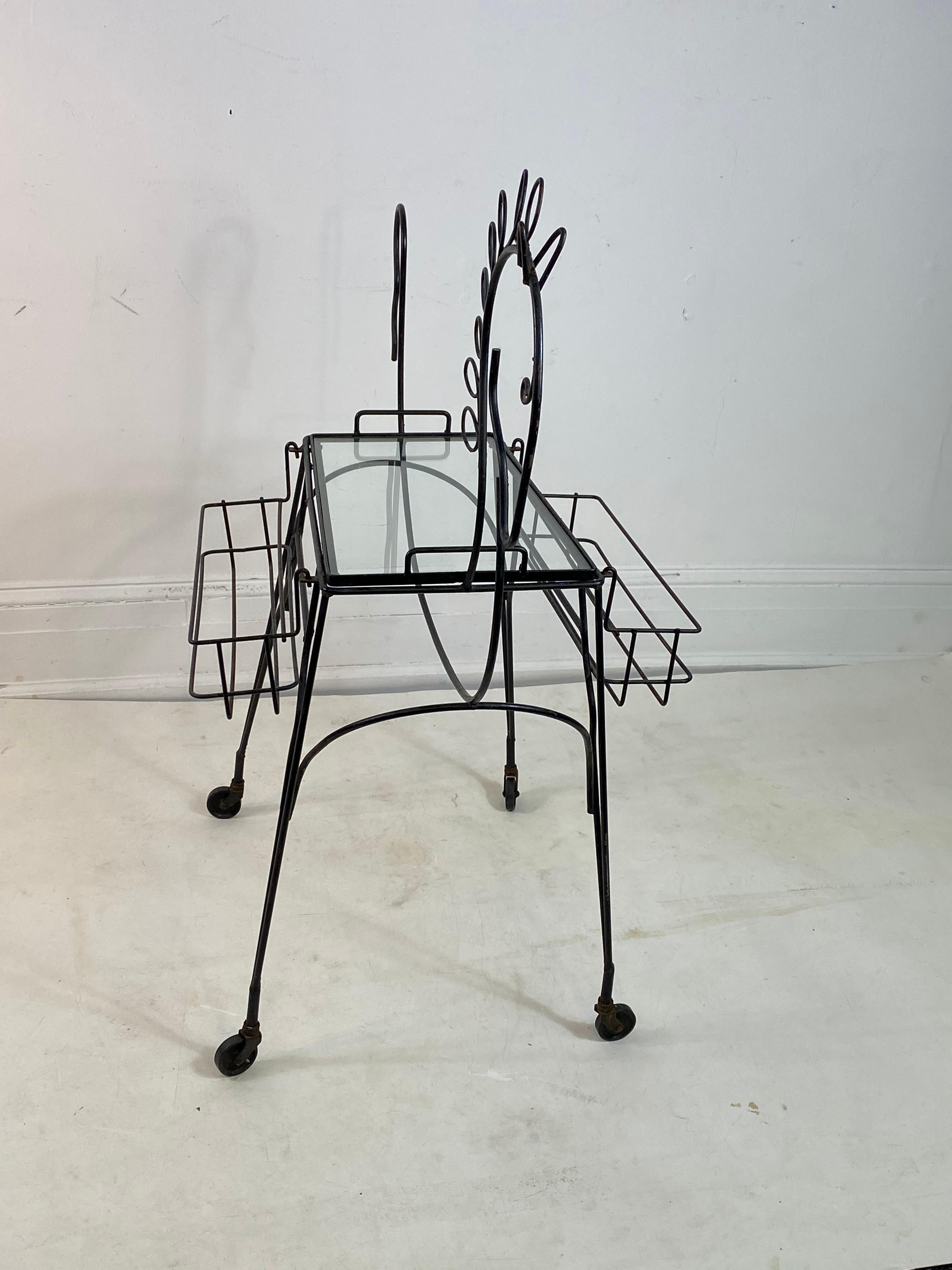 Whimsical midcentury black horse outline bare cart designed by Frederick Weinberg in the 1950s. Glass top center table with two bottle racks on each side. Designed with a black enameled metal frame depicting the stylistic horse. Mounted on wheels