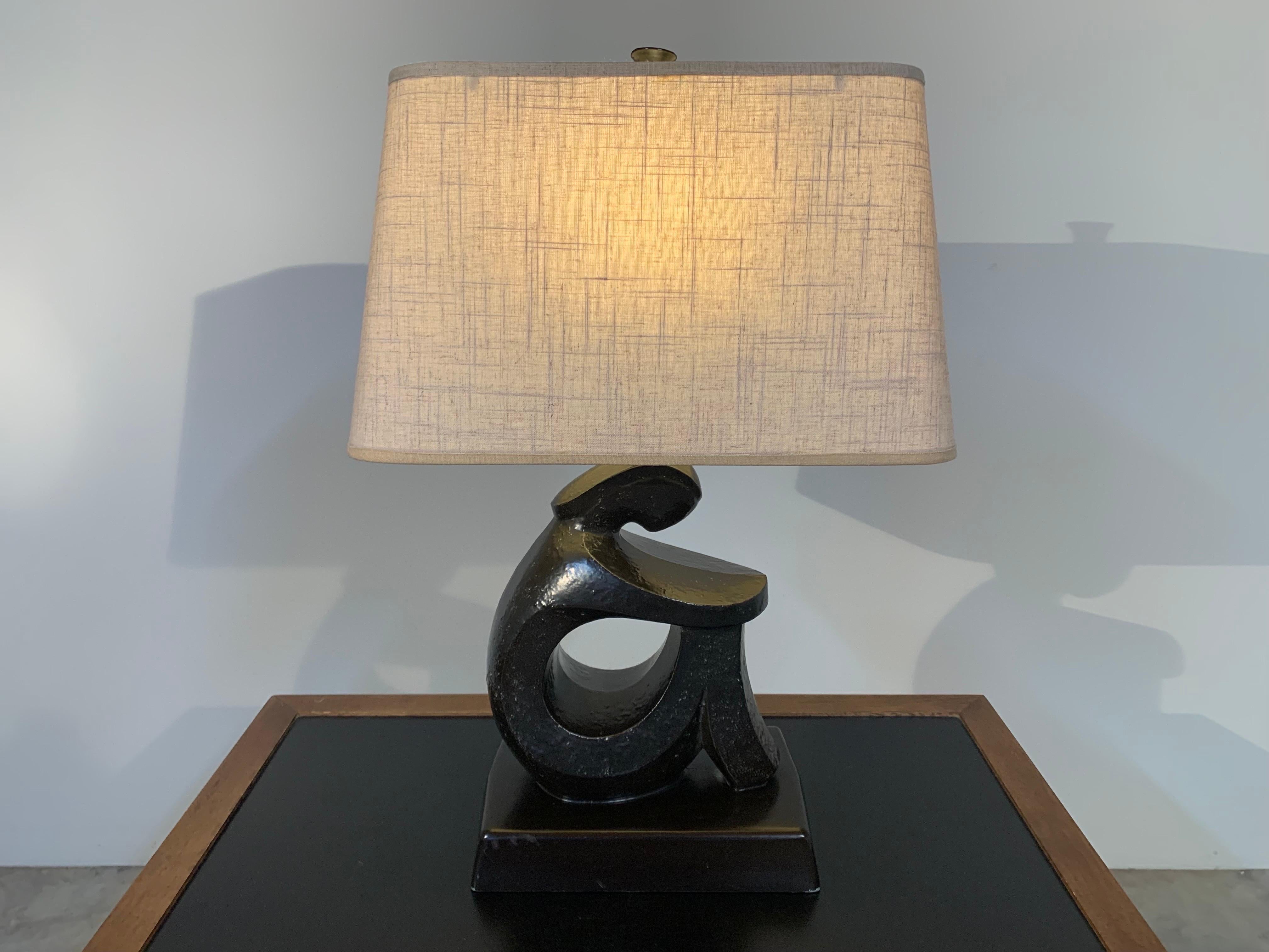 A fetching sculptural figure table lamp designed by Frederick Weinberg circa 1950 having cast aluminum sculpture with deep brown tone. A beautiful addition to any mid-century modern collection. Offered at a fantastic price and in outstanding