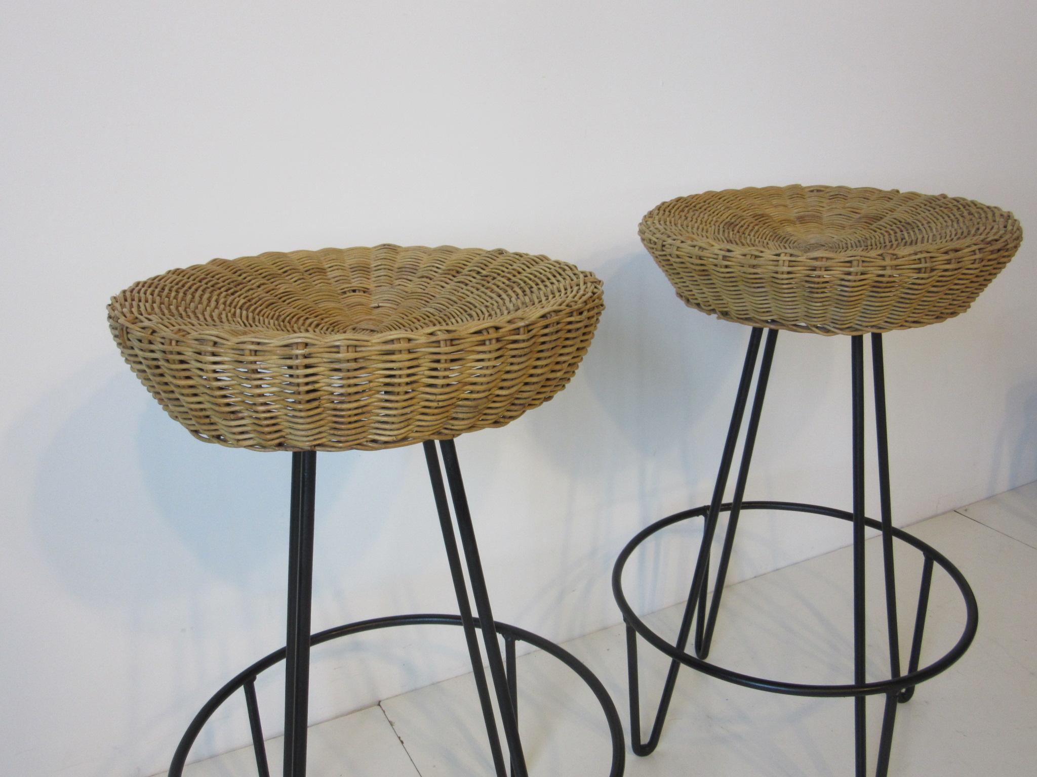 A pair of welded iron based bar stools with foot rests and woven wicker seats a great addition for that tiki bar or casual entertaining area. The measurement for the footrest ring is 18