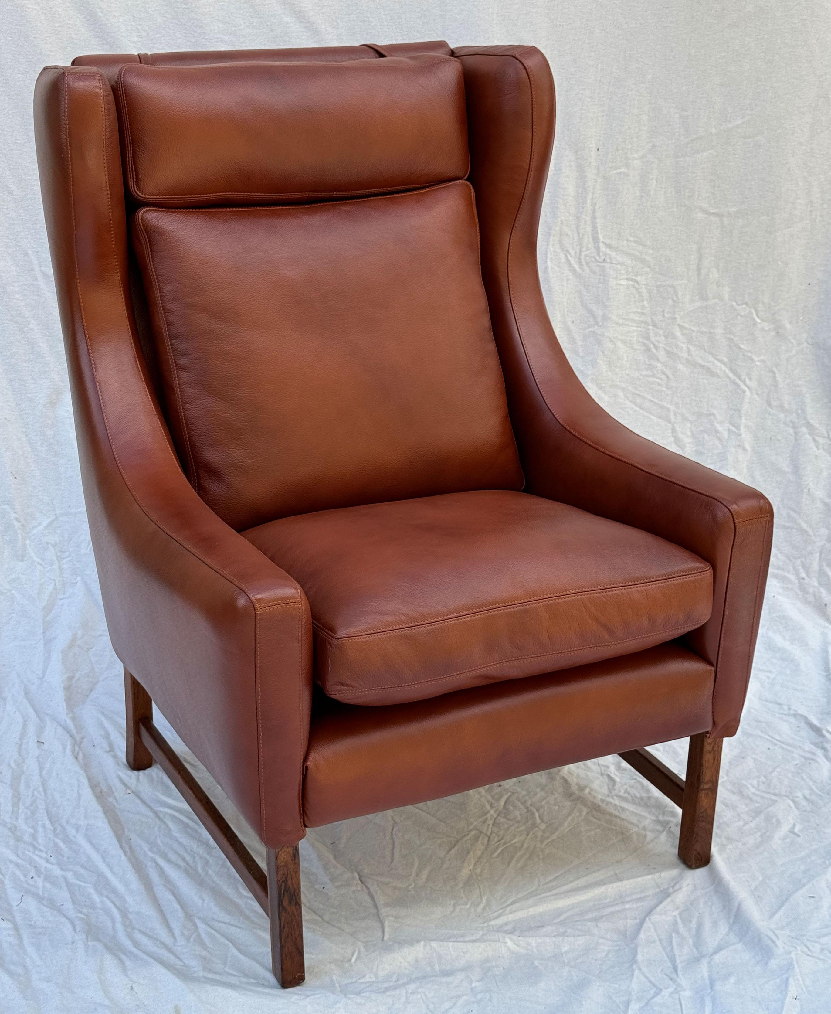 Cognac leather wingback armchairs, designed by Fredrik Kayser for Vatne Møbler, Norway, circa 1964. Hardwood legs, and adjustable headrests with weighted straps. 
New upholstery.

