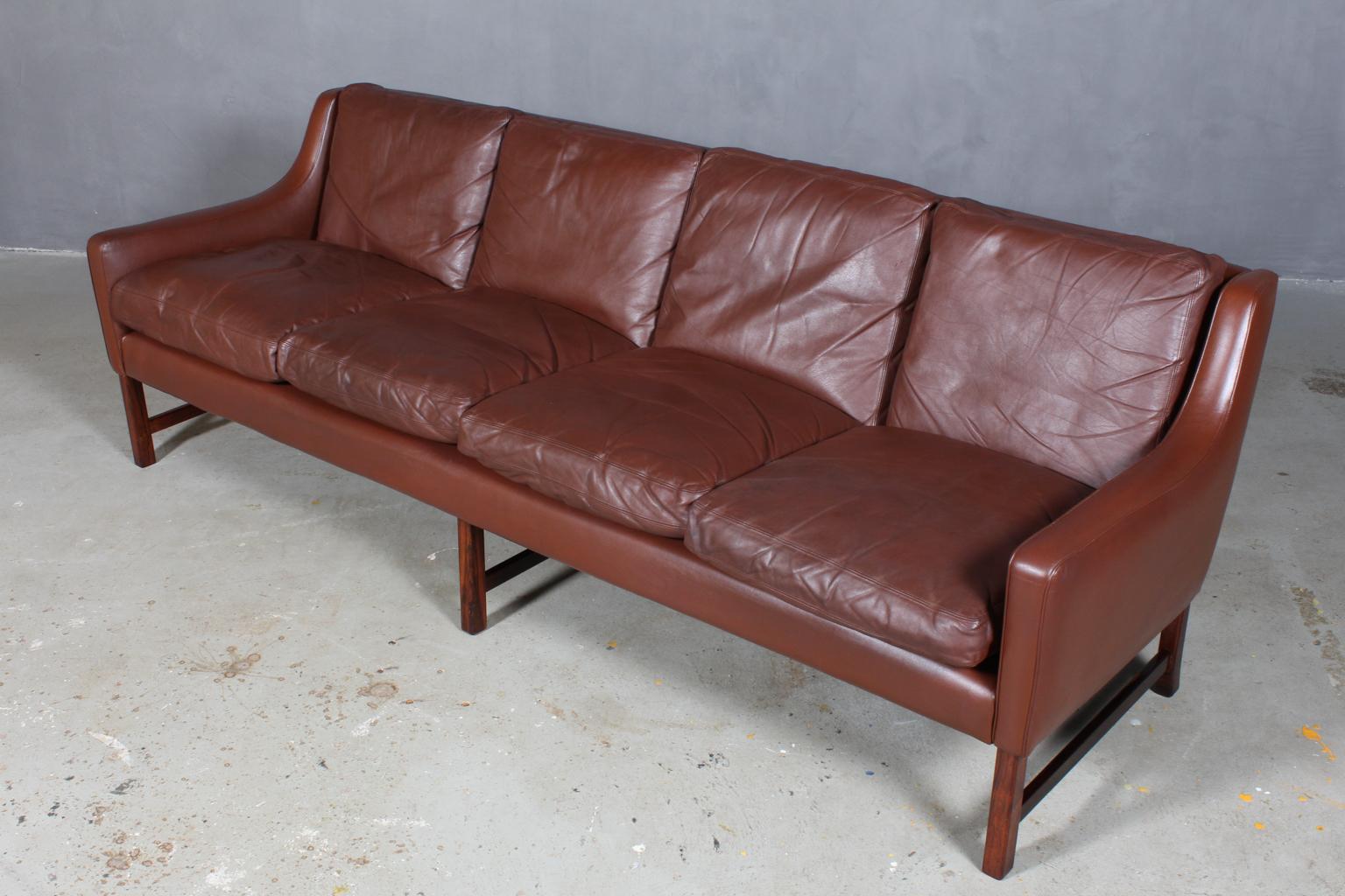 Fredrik Kayser four-seat sofa original upholstered with brown leather.

Legs of rosewood.

Model 965T, made by Vatne Møbelfabrik.