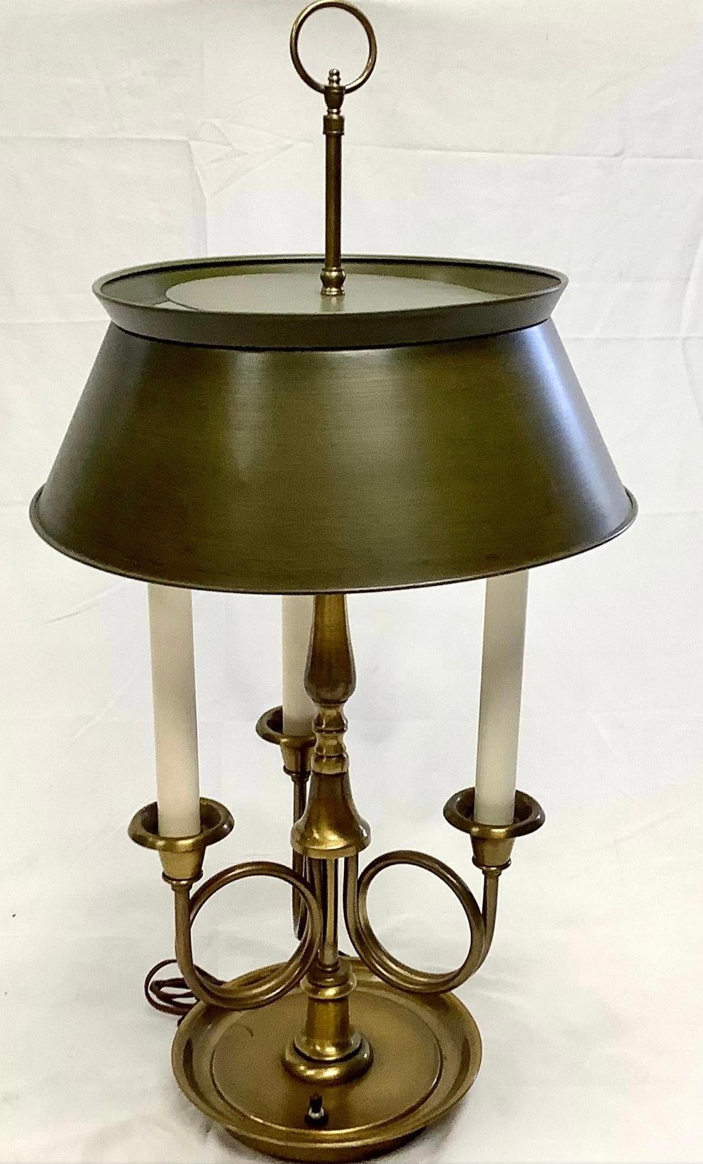 Fredrick Cooper French style brass Bouillotte lamp with dark green tole shade. Lamp has two light sockets and three faux candle holders. Age appropriate wear. In working condition.

Measures: 8