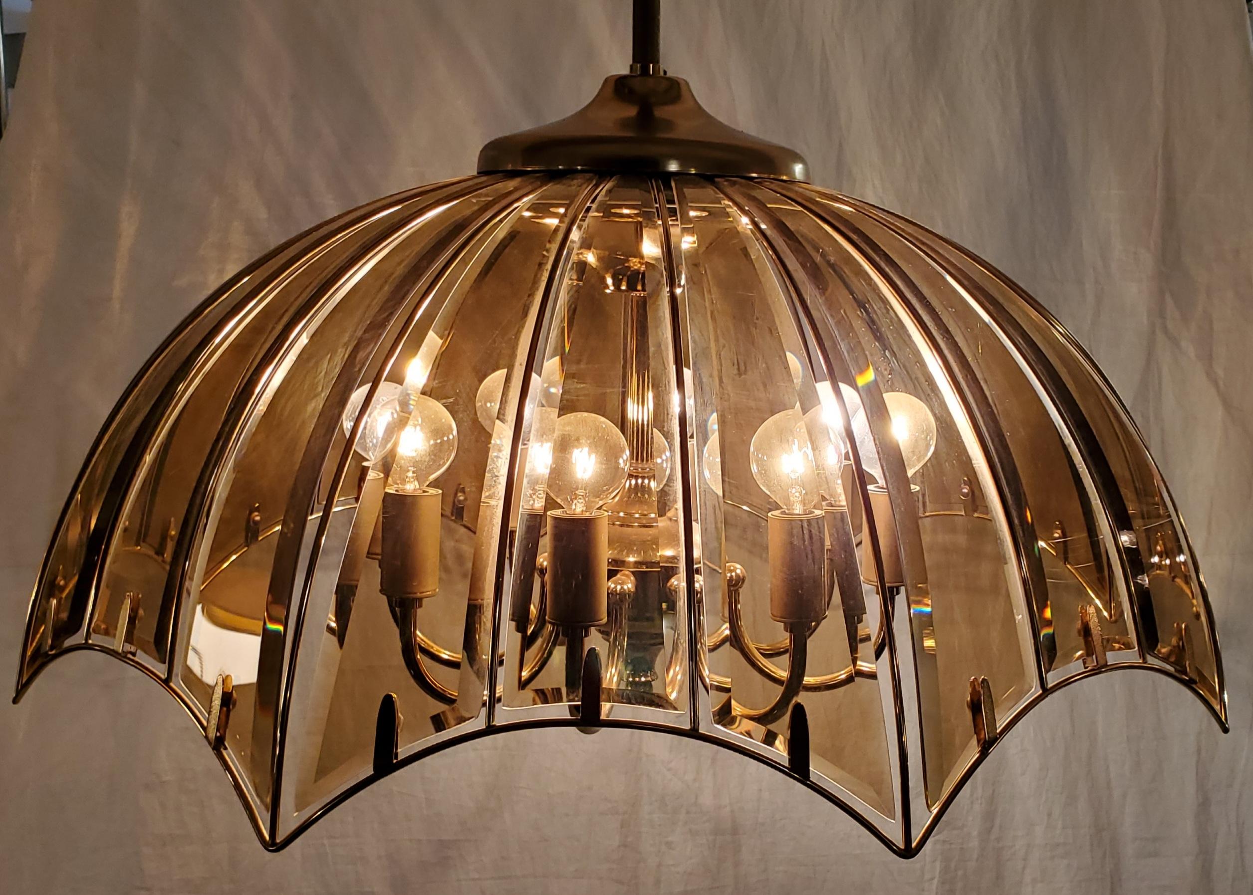 Stunning Mid Century modern Fredrick Ramond styled umbrella chandelier.
The beveled curved glass has a small tint and the outline is a golden metal. This chandelier has 8 lights.