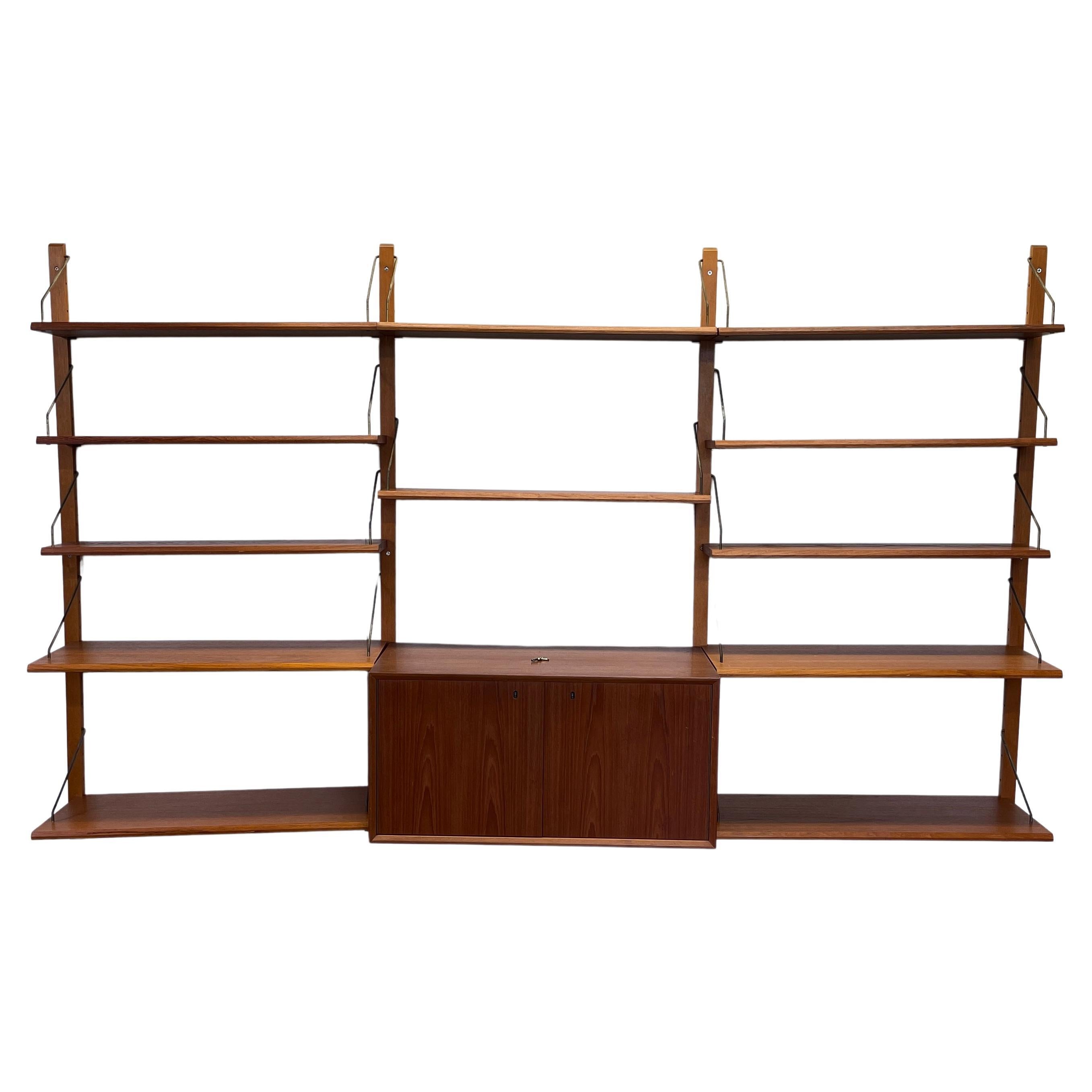 Step up your storage game with this gorgeous teakwood wall unit by Norwegian designer Fredrik A. Kayser. This wall unit is completely modular and can be set up as either a single 3-bay unit or as two single-bay units. When set up as a 3-bay unit it