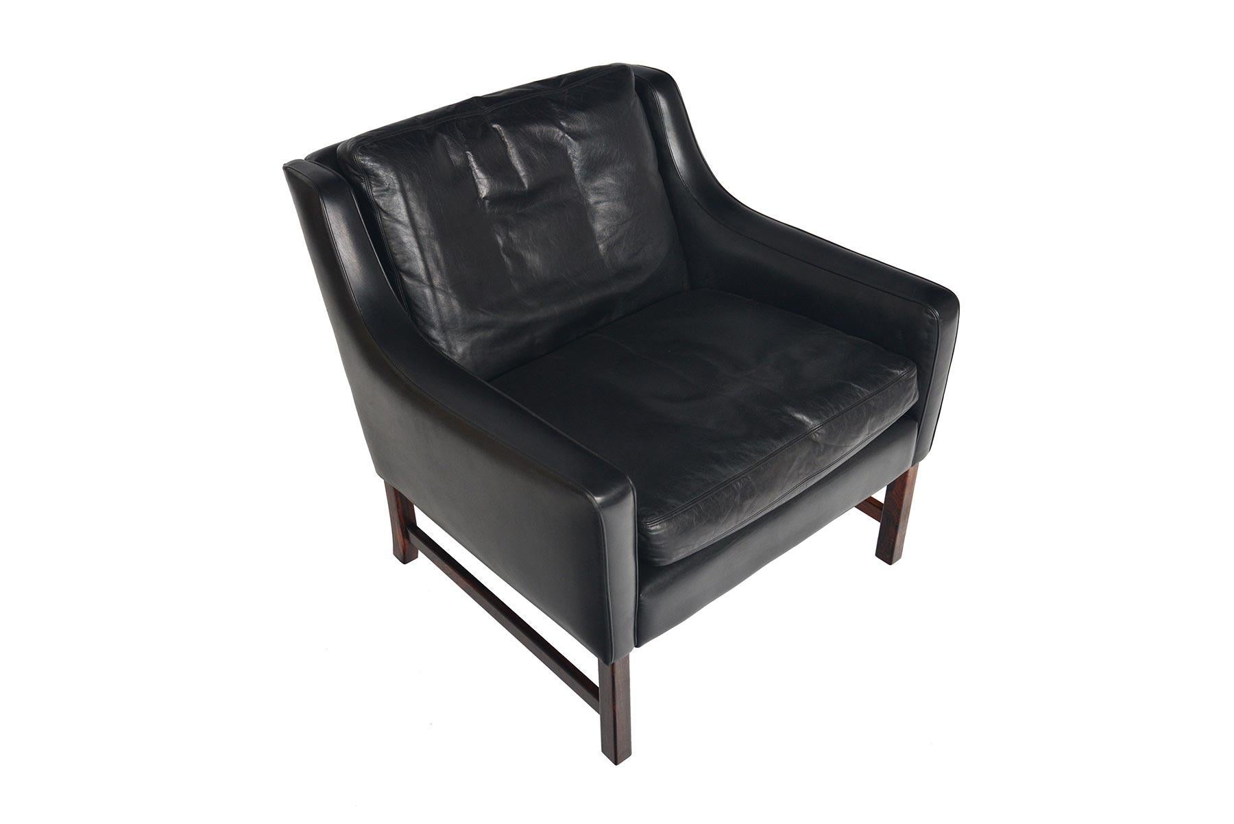 This beautiful Fredrik Kayser lowback lounge chair was produced for Vatne Møbler in the 1960s. This streamlined chair is covered in a beautifully preserved, original black leather. Two down- stuffed cushions sit in the frame. Chair stands on a