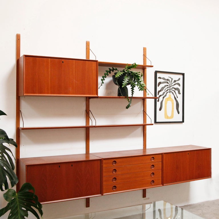 Stunning wall mounted unit in teak by Fredrik A. Kayser, Norway. This 3 Bay modular unit can be configured in different ways to suit anyone's storage needs. Four cabinets and four shelves provide plenty of storage. The 3rd bay has a short rail - the
