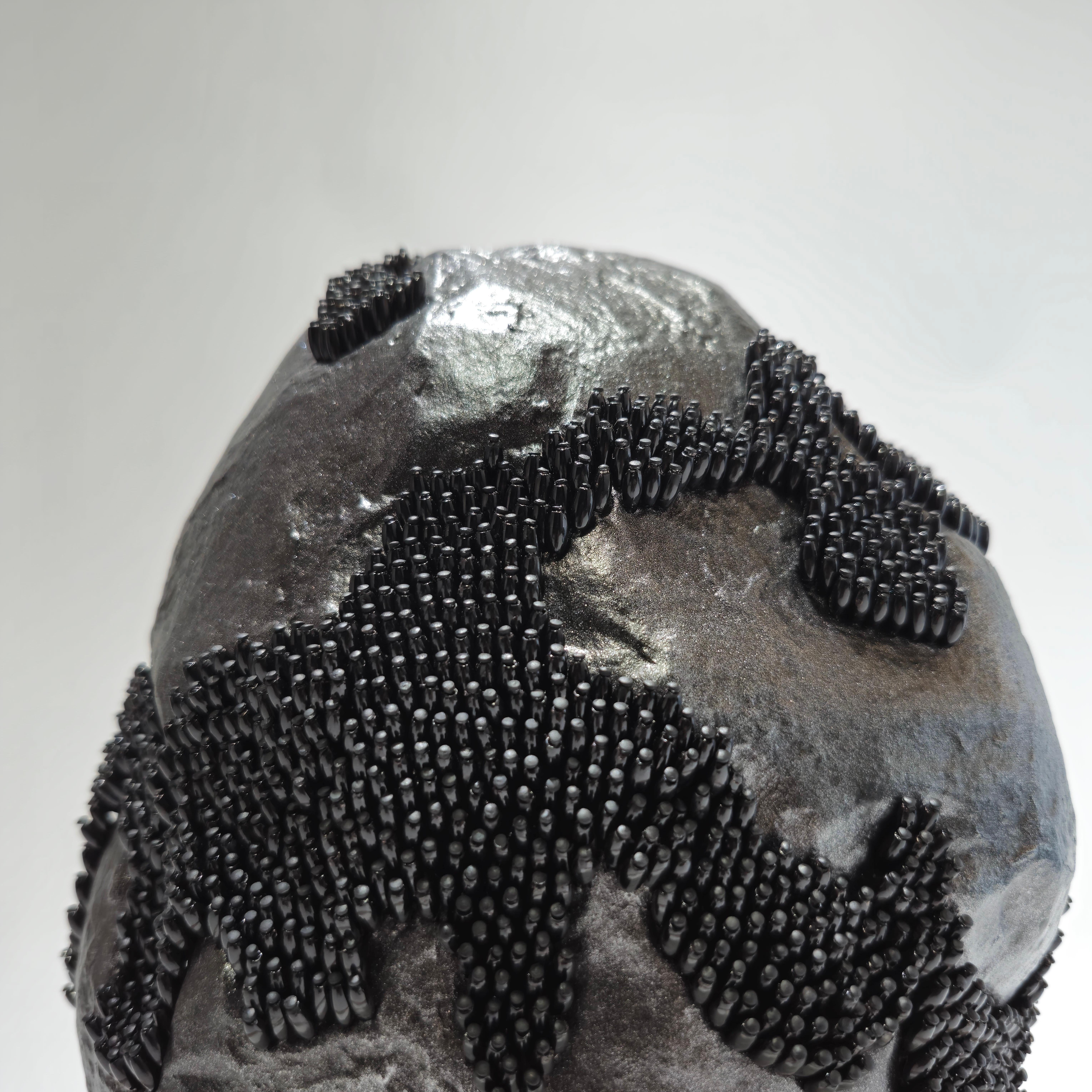 The artwork is a three-state model of an inorganic body, beginning with a black, alien-like rock formation, which gradually unfolds as it evolves, revealing its contents as a whitish crystal with unknown properties.

Serrano's artistic work centers