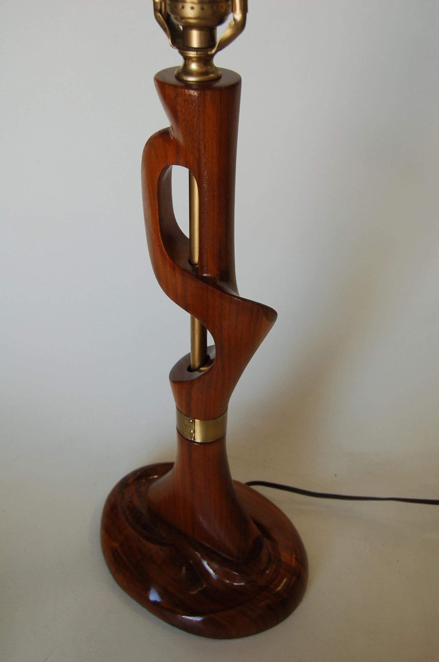 Freeform modernist carved mahogany table lamp and nailhead brass detail by Jascha Heifetz.

Measures: 9