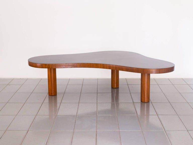 Beautiful free-form table, beautiful patina. A variation on the Classic three feet table design by Royère, with black formica top. A table that looks great from whatever angle you look! Fomica top has some gouges and deep scratches. The top edges