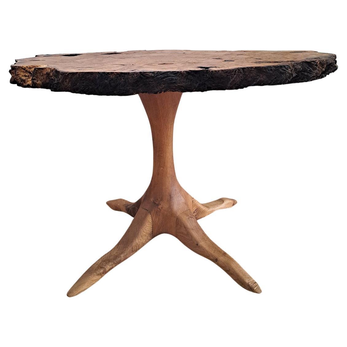 Sehr eleganter Beistelltisch aus Ulmenwurzelholz mit lebendiger Kante. Dieser Tisch im brutalistischen Stil ist aus knorrigem Holz gefertigt. Gedrehter Sockel auf vier geschnitzten Füßen, ebenfalls aus Ulme, die an Vogelfüße erinnern. Entworfen von