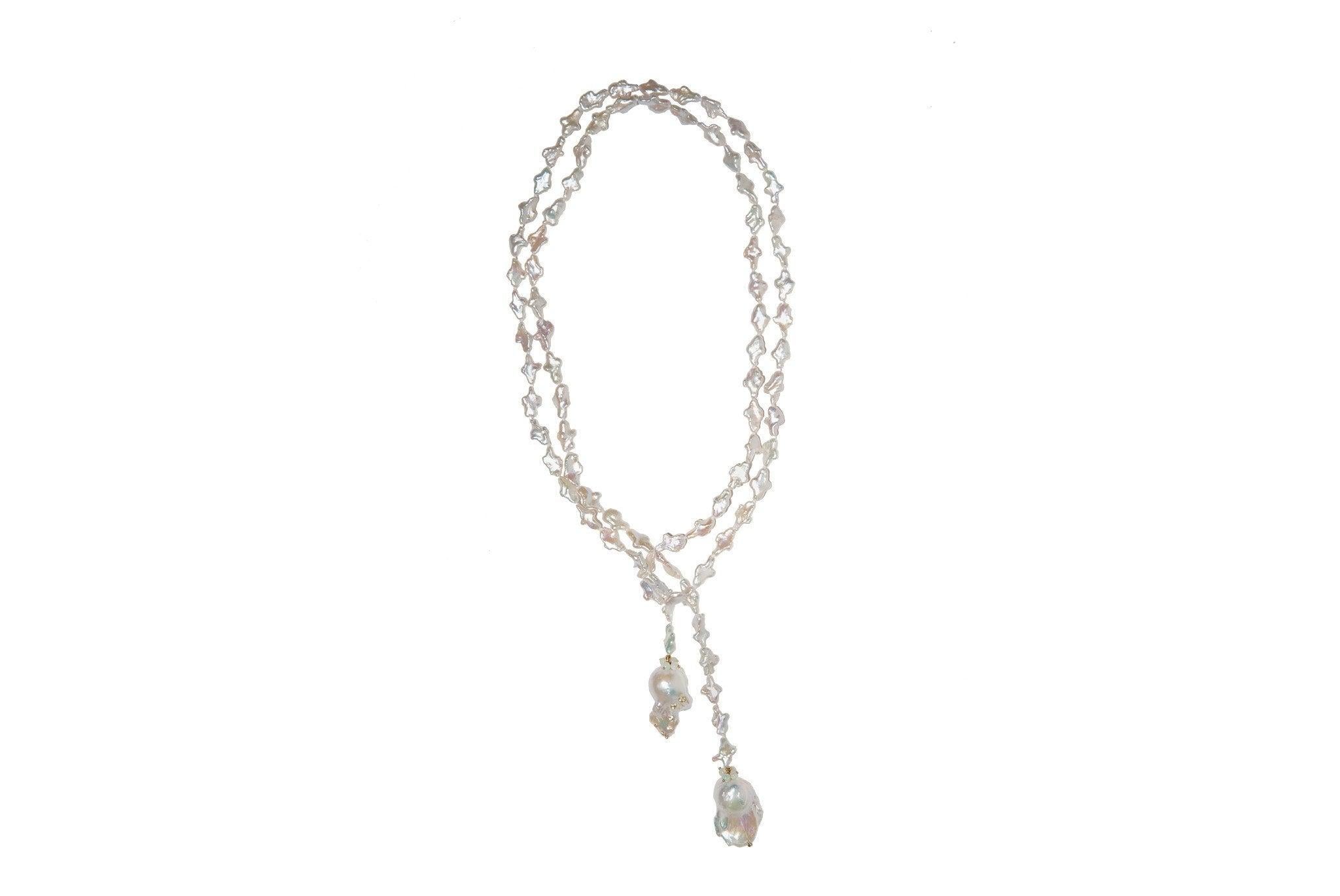 A rope of most unusually shaped freshwater pearls terminate at either end with large Baroque pearls which have been studded with 18k bezel set white topaz. This lariat yearns to be worn long for a dramatic effect or double looped for  up close