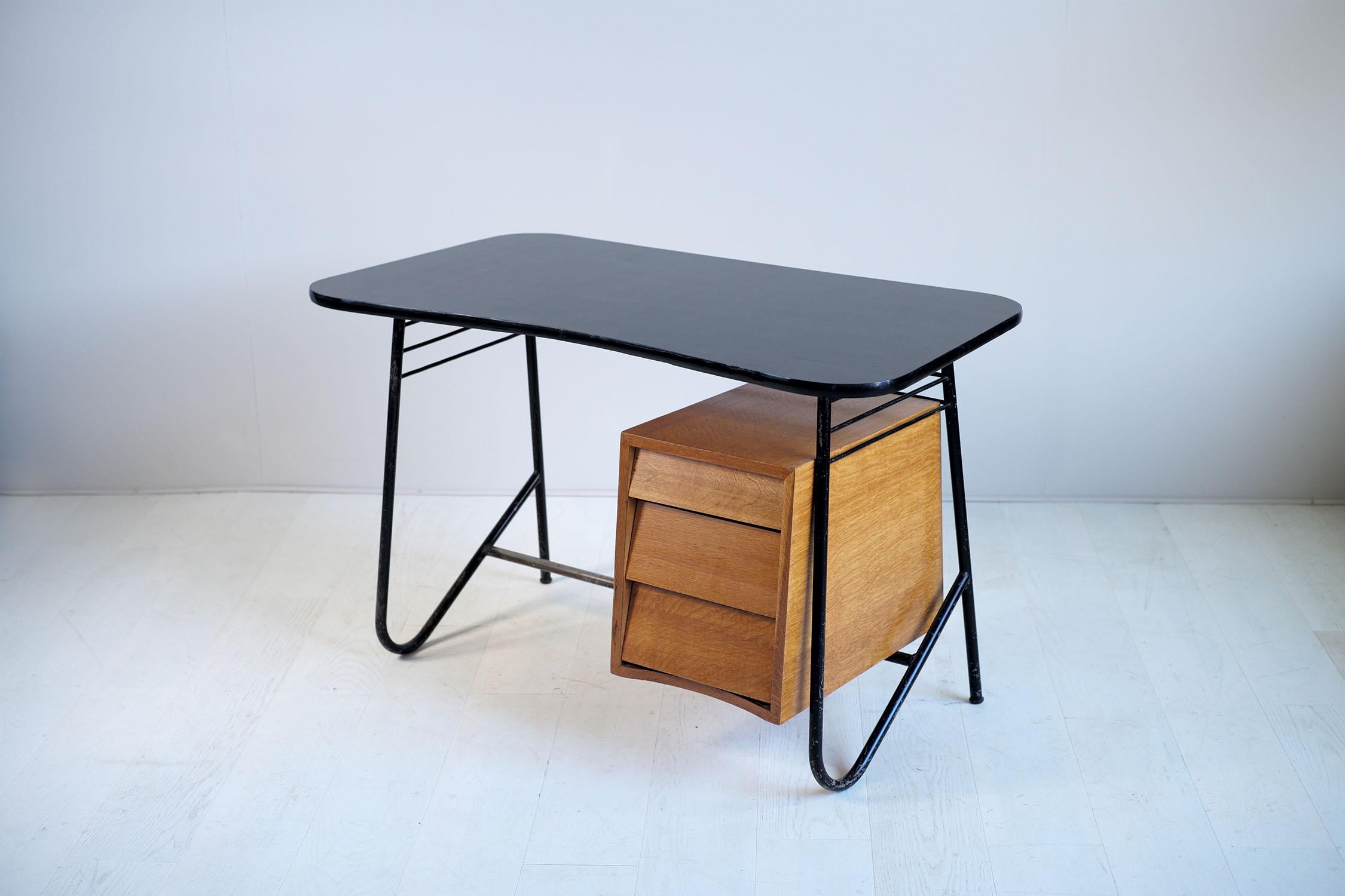 Black lacquered tubular metal free-form desk, three drawers oak cabinet and black formica top. The base is highlighted by a row of three slings, the kidney shaped tray and cutaway drawers give this creation of the French fifties a remarkable