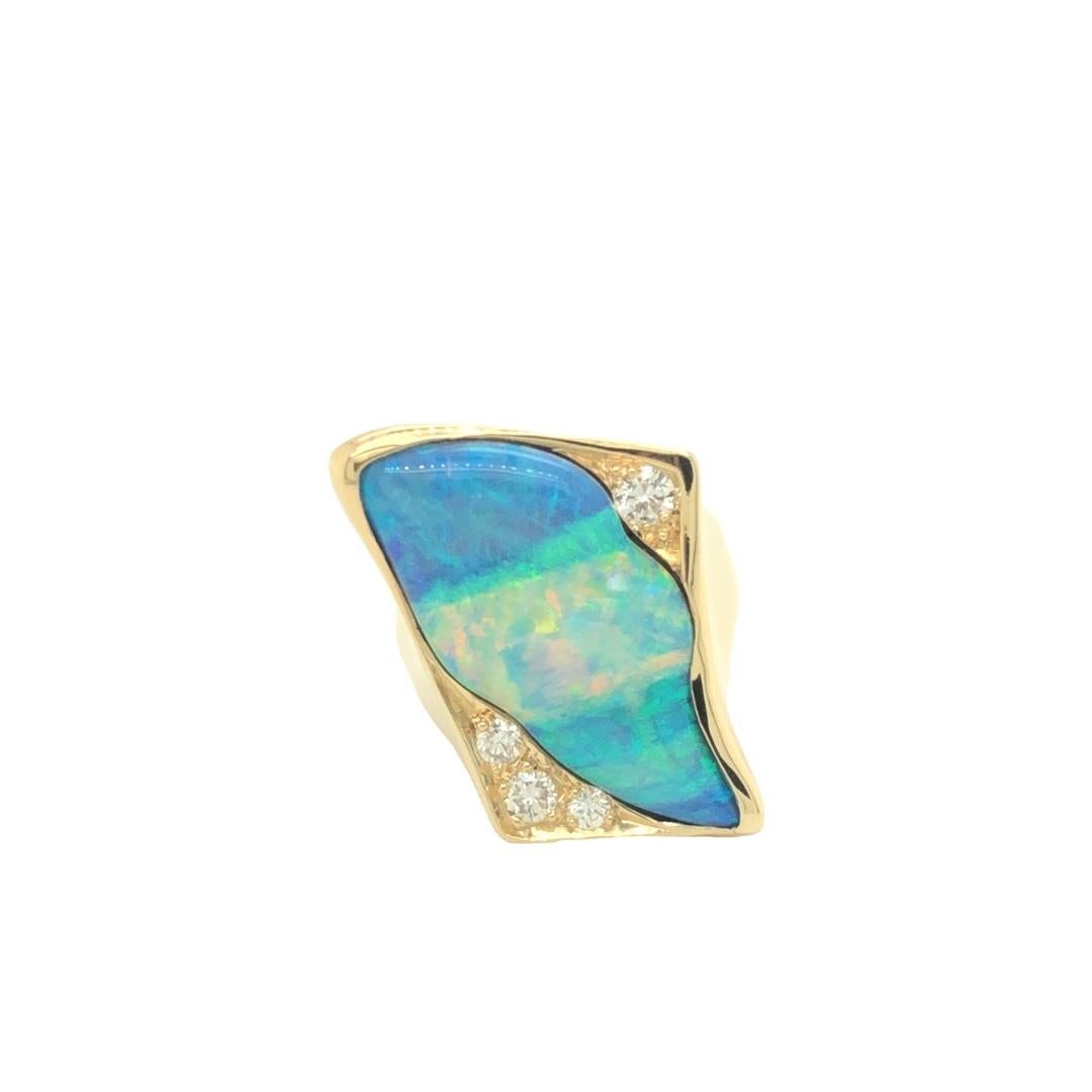 Circa 1980s, this unique statement ring features a beautiful opal at center. The opal is accented by 4 round brilliant cut diamonds weighing approximately 0.50 ct total. The ring is crafted in high polished 18K yellow gold. 

The top of the ring
