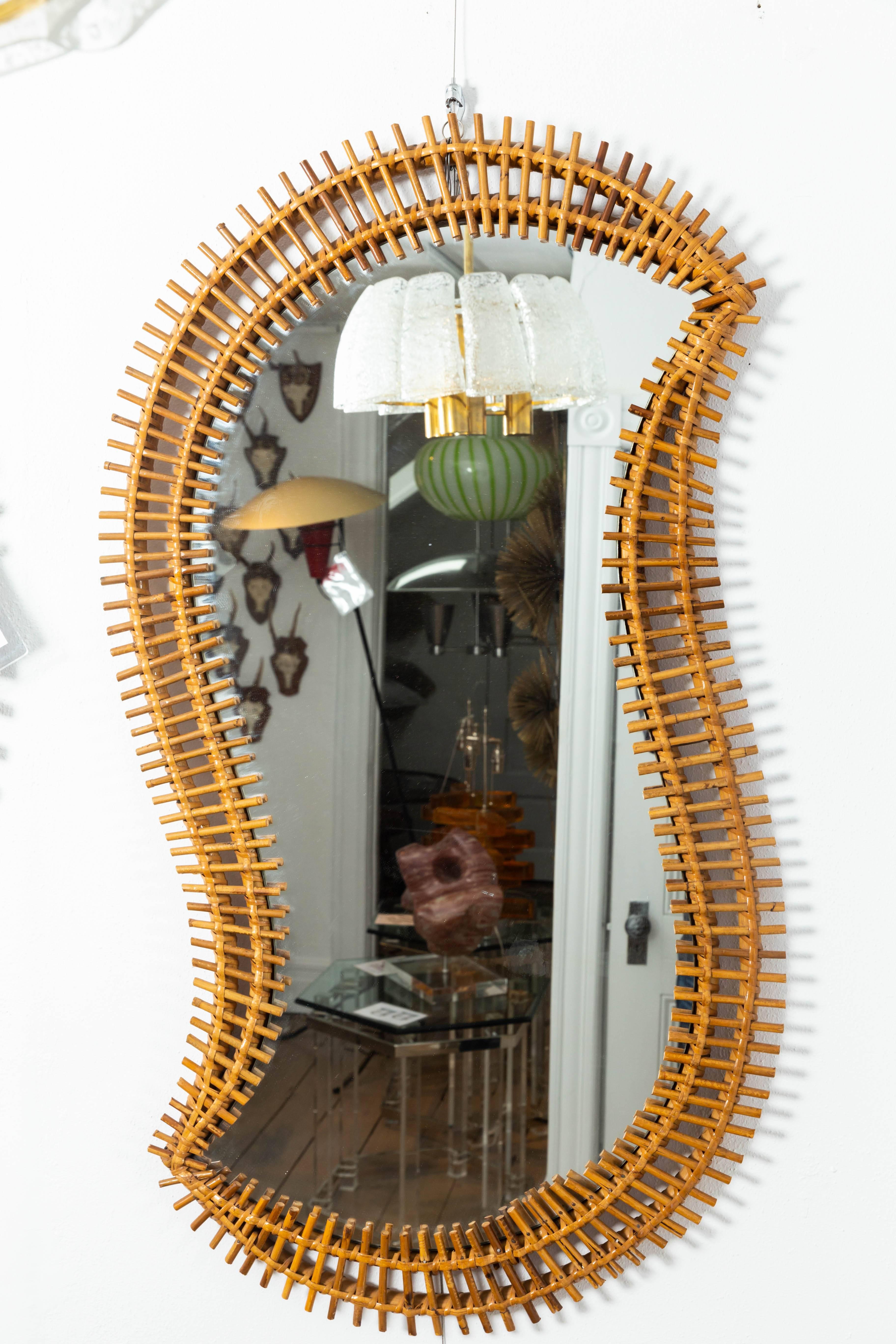 Free-form rattan surround mirror.