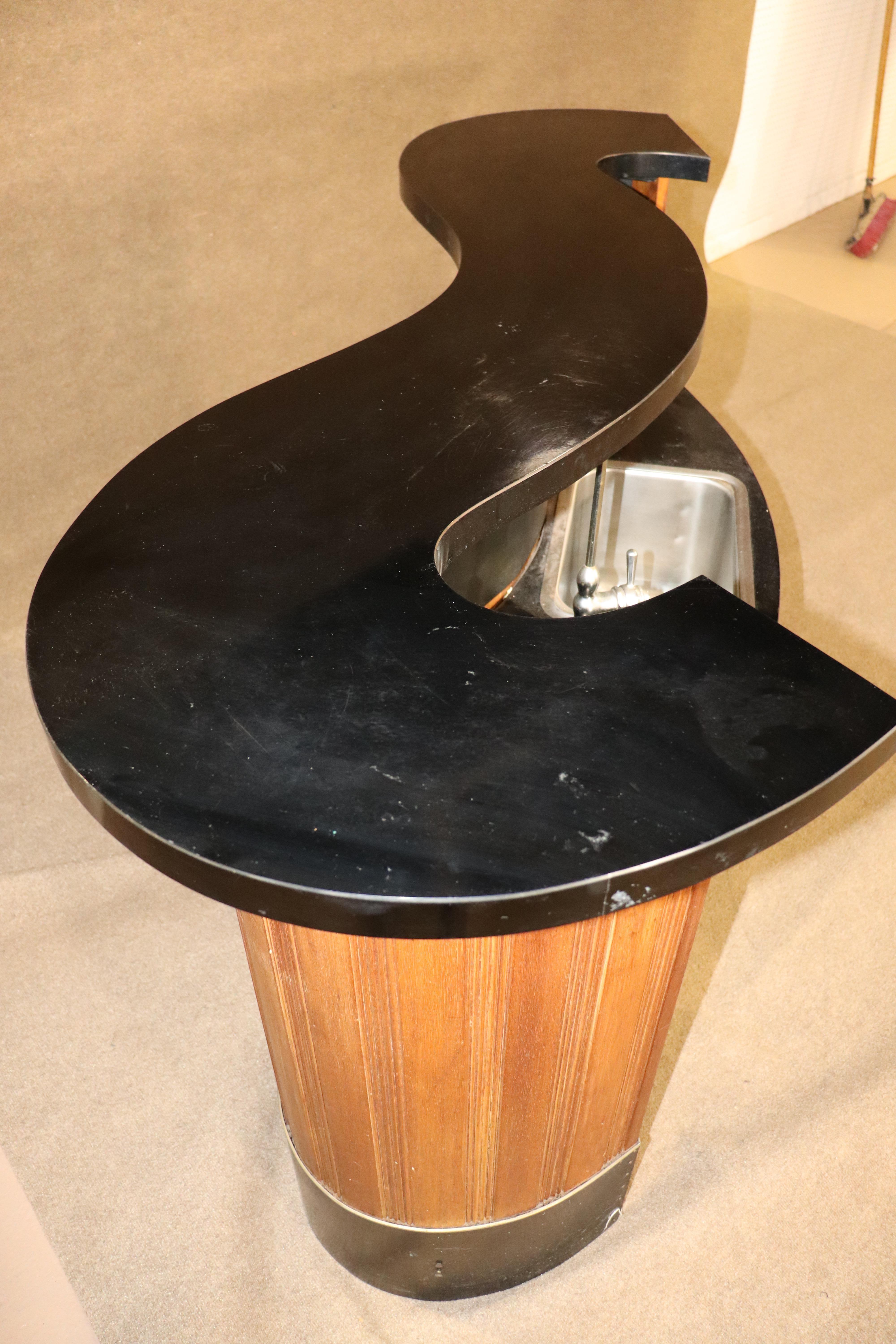 Mid-Century Modern home bar with sink and water hook up. This wet bar has a fun winding top. 
Please confirm location NY or NJ.