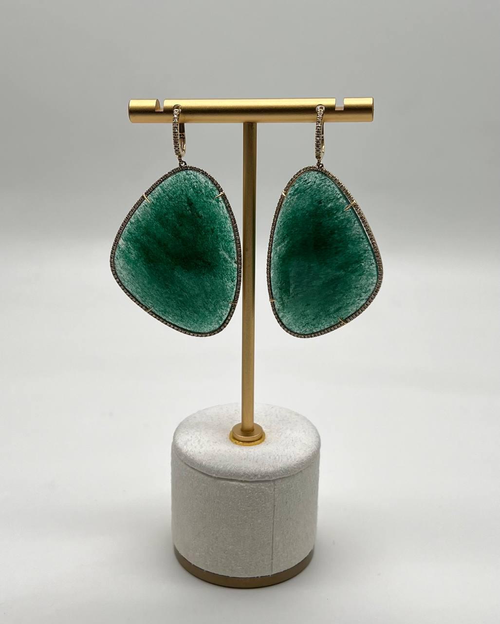 Dark Green Aventurine. Rich green hues radiate from these striking earrings, framed by delicate pavé accent diamonds 0.80 ctw. The organic, asymmetrical shapes create a bold statement, suspended elegantly from a slender gold hoop. Rendered in 14K