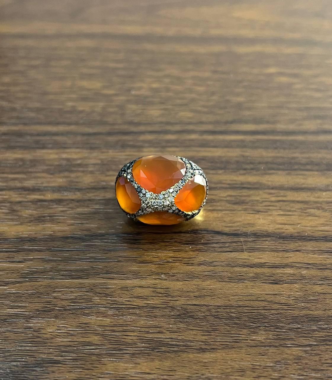 Discover the captivating charm of this exquisite ring.

Featuring a stunning 23.64-carat orange carnelian, this piece is a testament to elegance and craftsmanship.

The ring is adorned with intricate detailing, set in luxurious 14k gold, enhancing