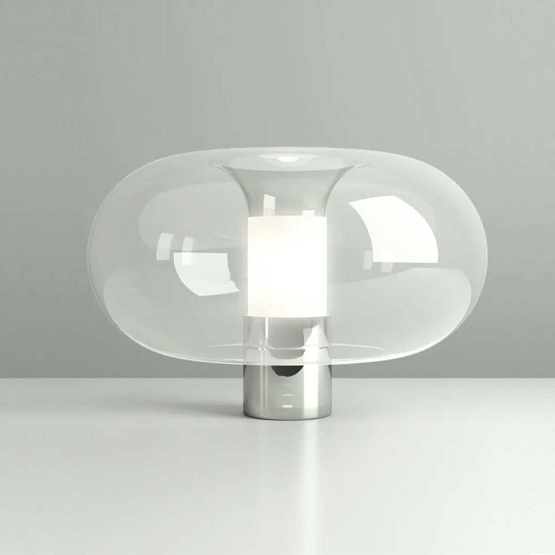 The Fontanella Table Lamp from FontanaArte presents personalized Italian craftsmanship, showing off luminous artistry. Designed by Federico Peri, this contemporary masterpiece marries a rounded shade of crystalline glass with a simple central