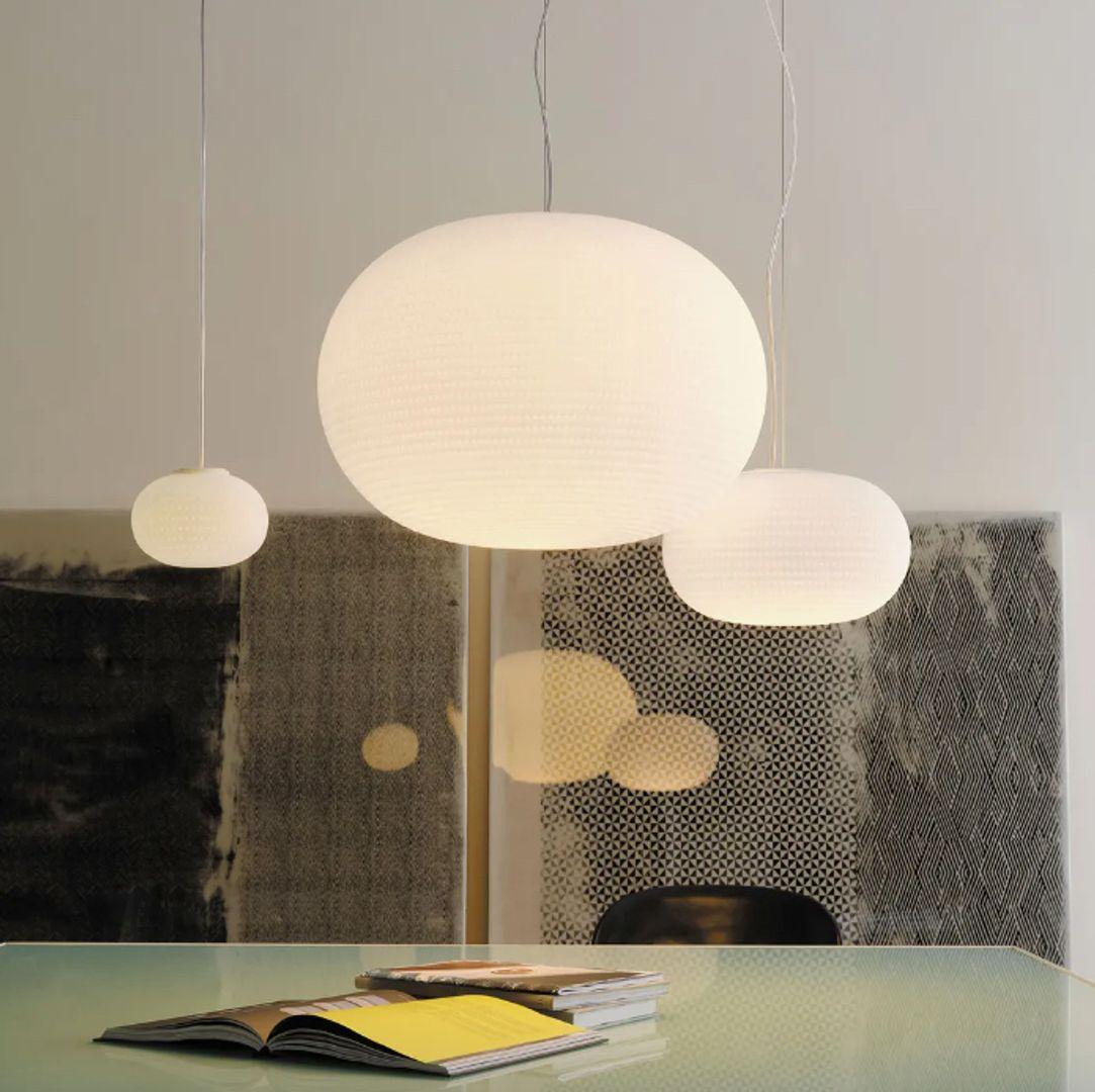 La suspension Bianca de FontanaArte est une charmante famille de lampes, chacune dotée d'un diffuseur magnifiquement texturé avec des rainures délicates et peu profondes gravées dans le verre blanc, rappelant de légères empreintes de pas sur la